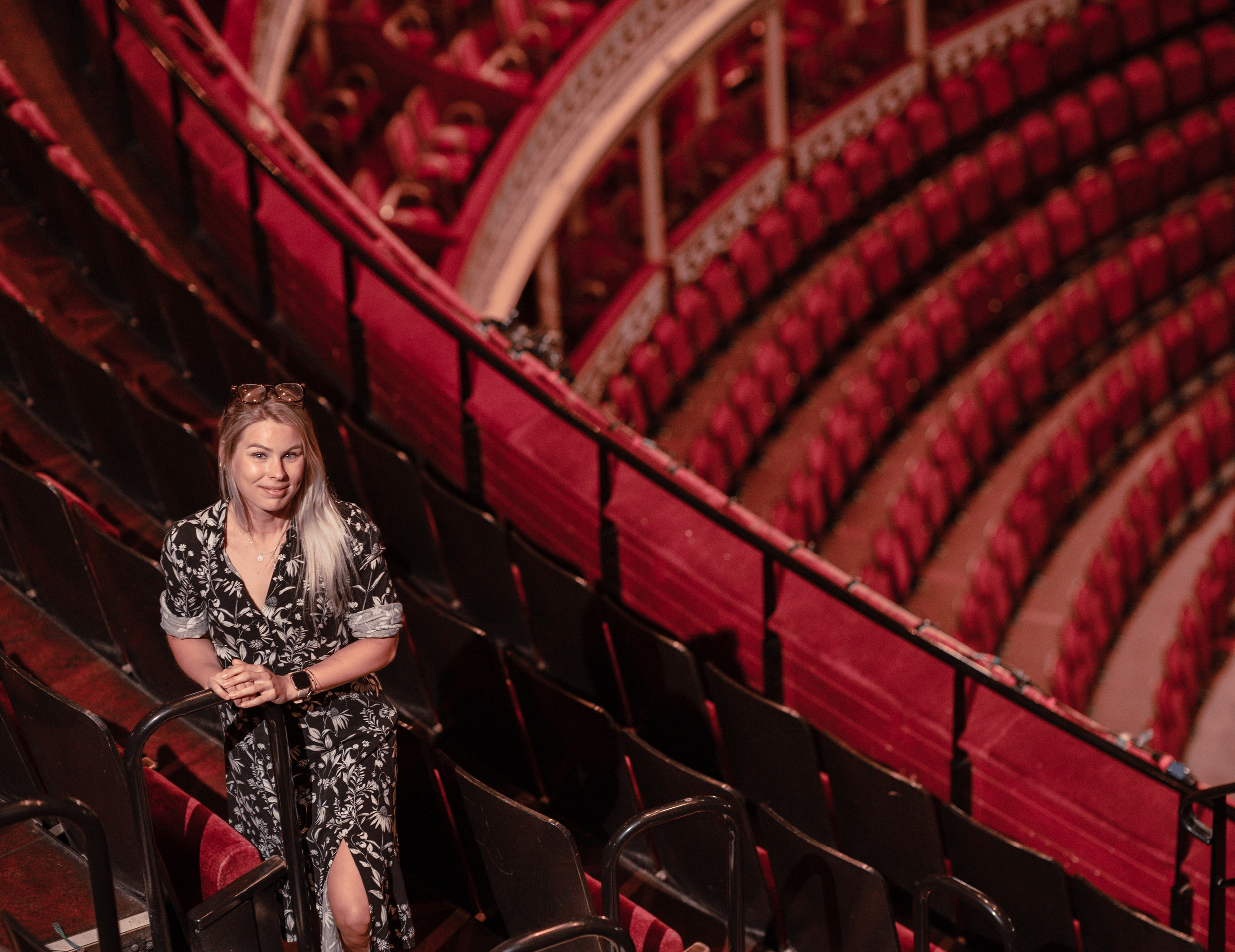 Looking down on woman stood amongst theatre seats