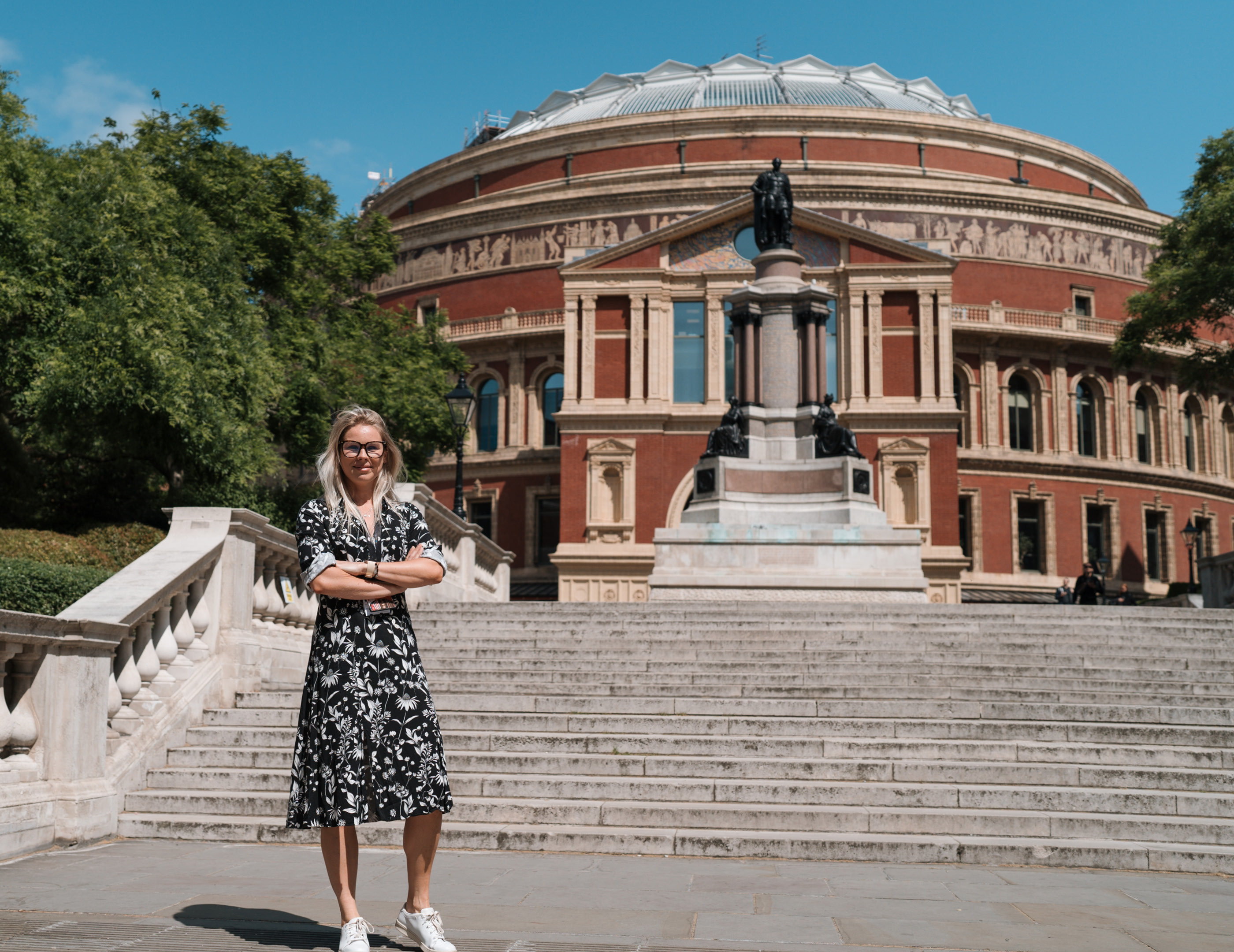 Woman stands with arms folded in front of the stairs outside the royal albert hall
