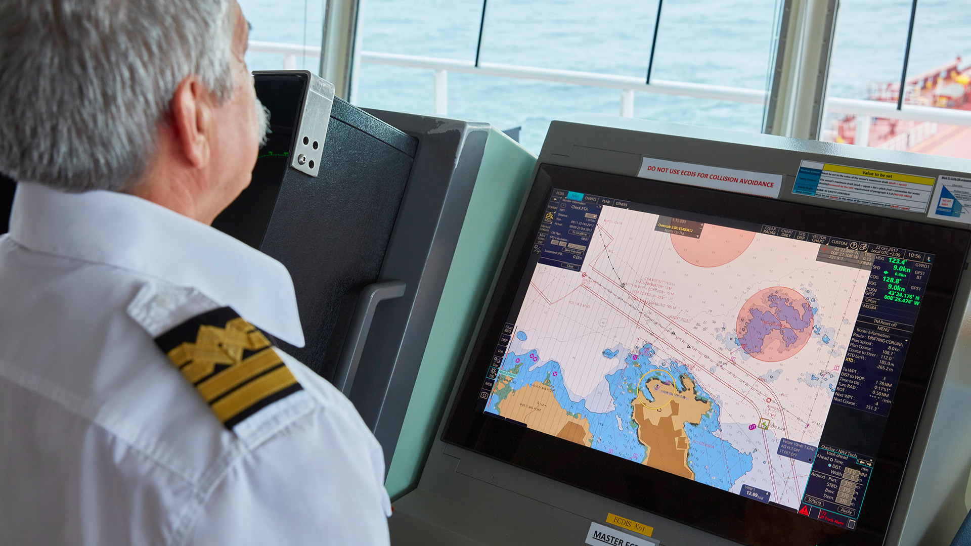 Captain steering ship with view of seabed map