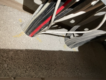 Cable penetrations through compartment wall with missing firestopping.