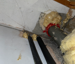 Expanding foam used to seal oversized core holes around a fire collar.