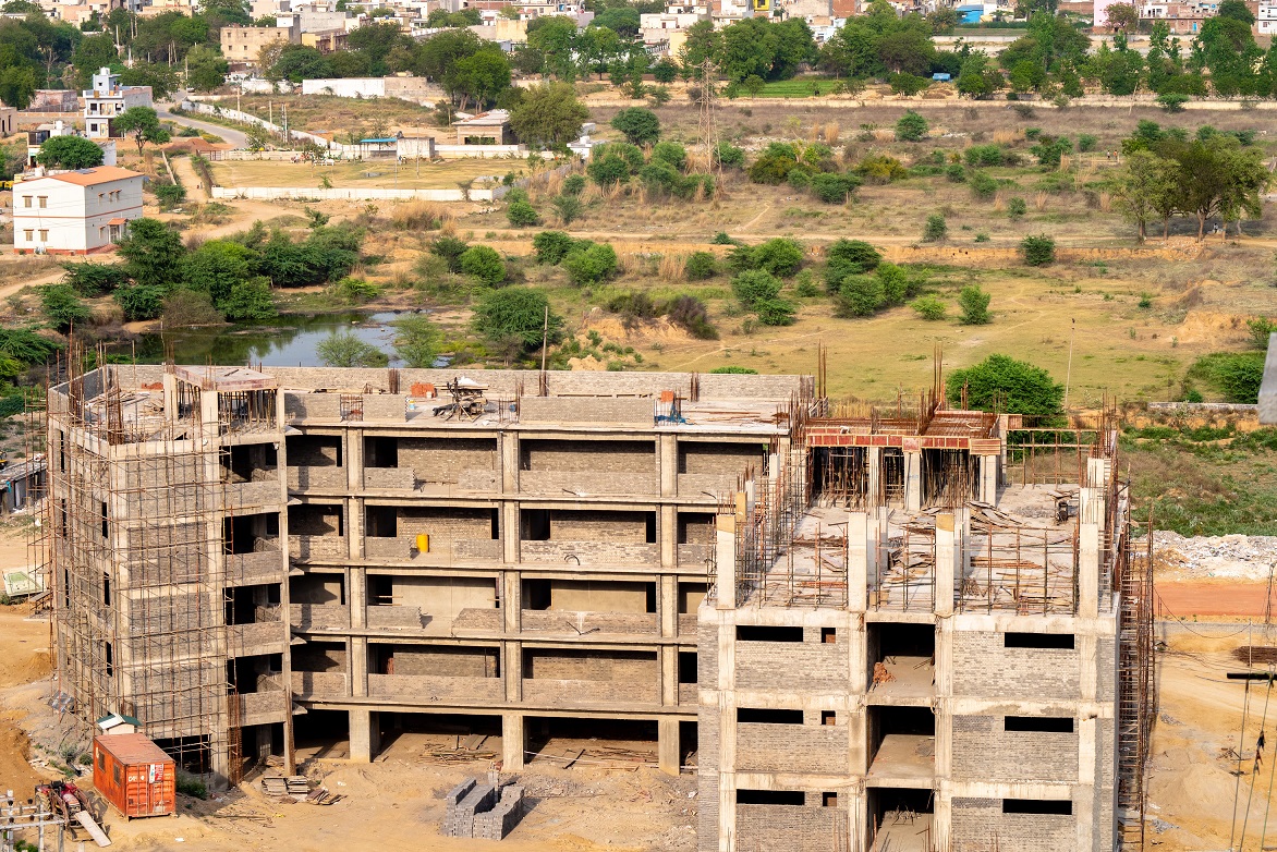 Aerial shot of the skeleton of an under construction school multi story building in developing countryside, India