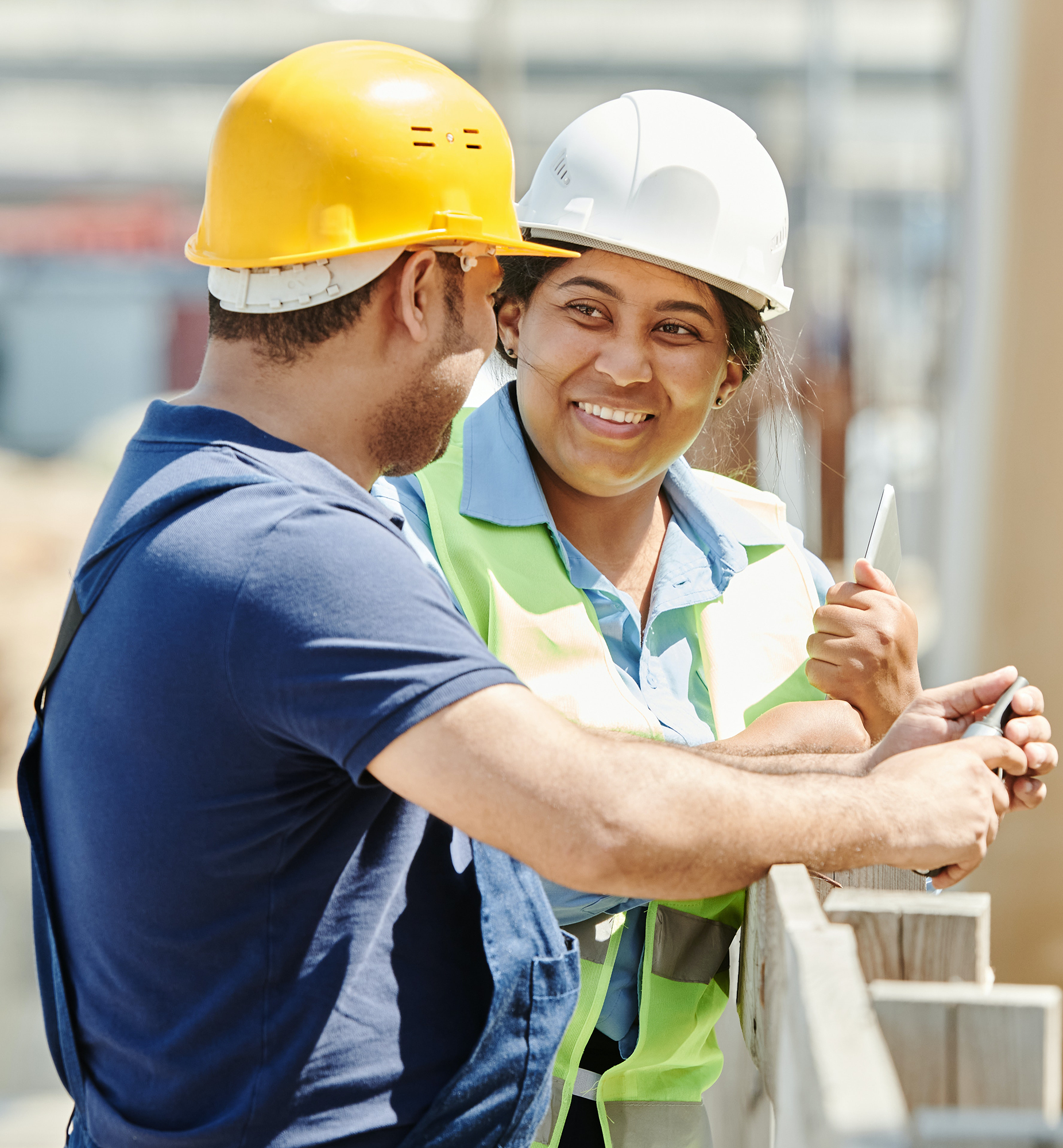 Woman and a man on building site, wearing hard hats
