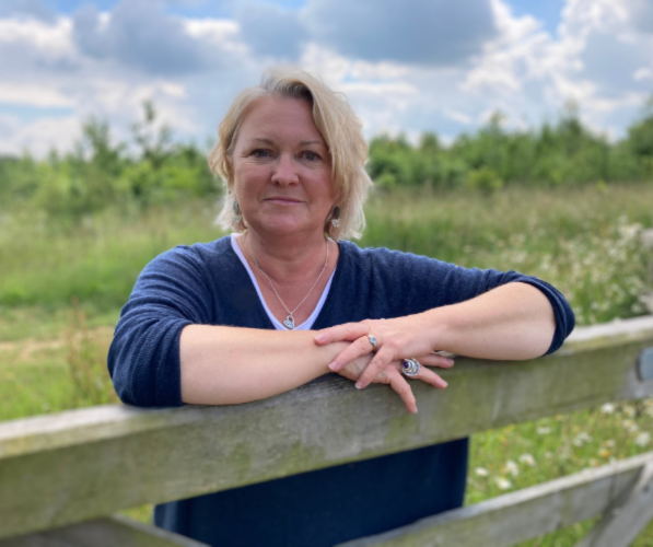 Sue Pritchard leaning on farm gate