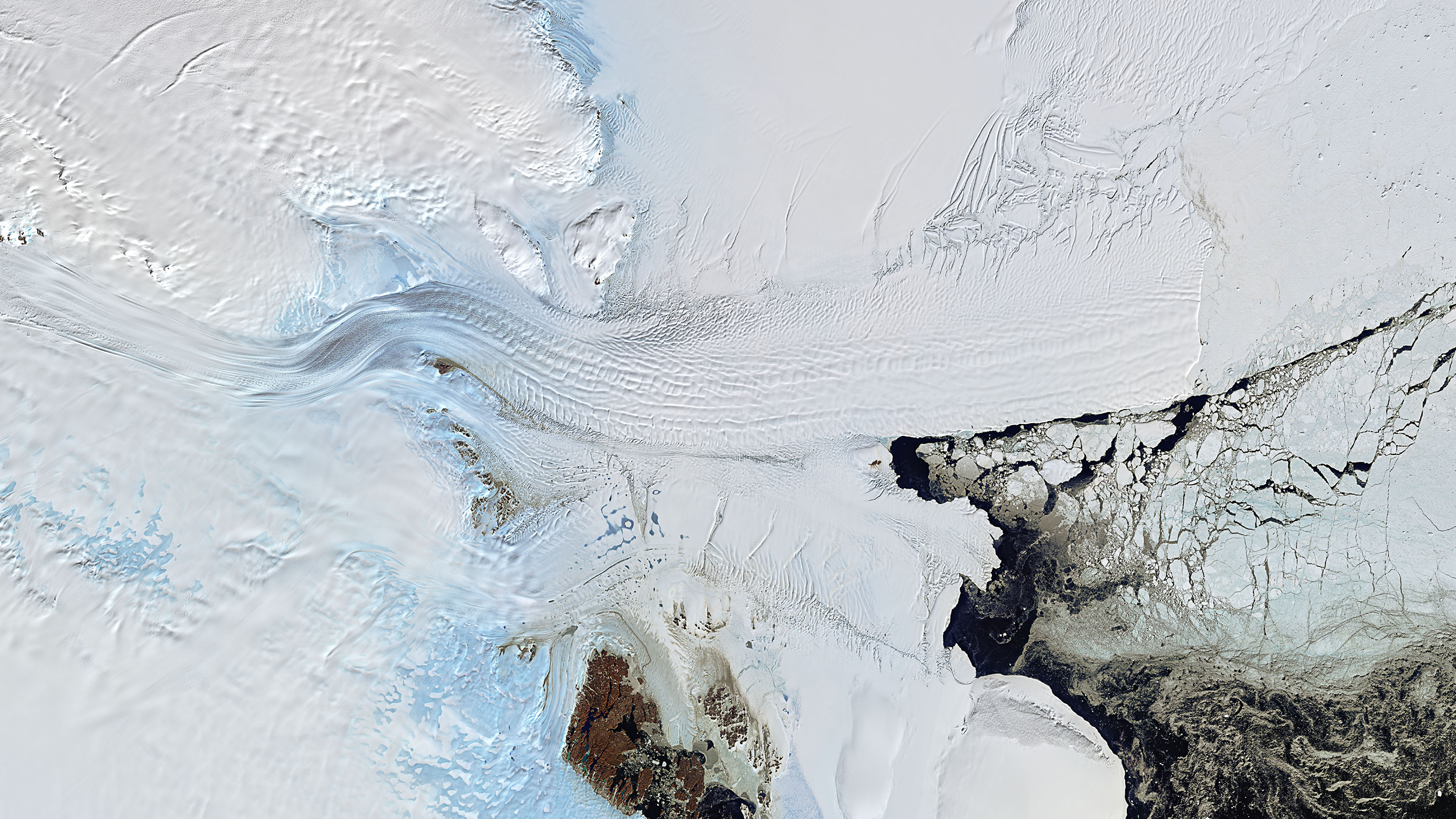 Denman Glacier flowing from left to right. From about the centre of the image the glacier is now fully afloat and known as the Shackleton Ice Shelf. The ice shelf is being melted from below by the ocean and icebergs break off from its front
