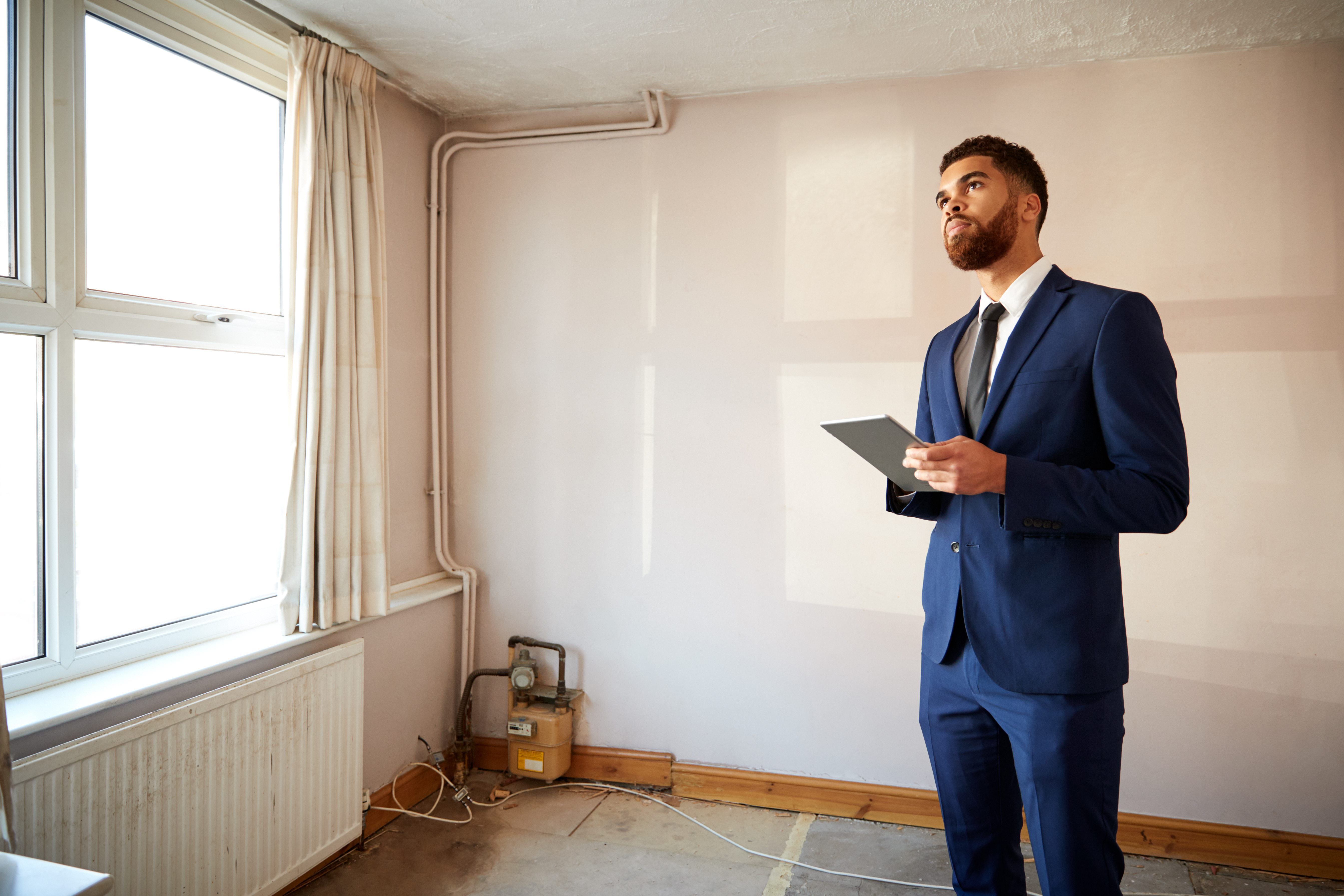 Male Realtor With Digital Tablet Carrying Out Valuation On Property For Renovation; Shutterstock ID 1273187872; purchase_order: N/A; job: RICS EU Valuation Campaign; client: RICS_PP; other: 