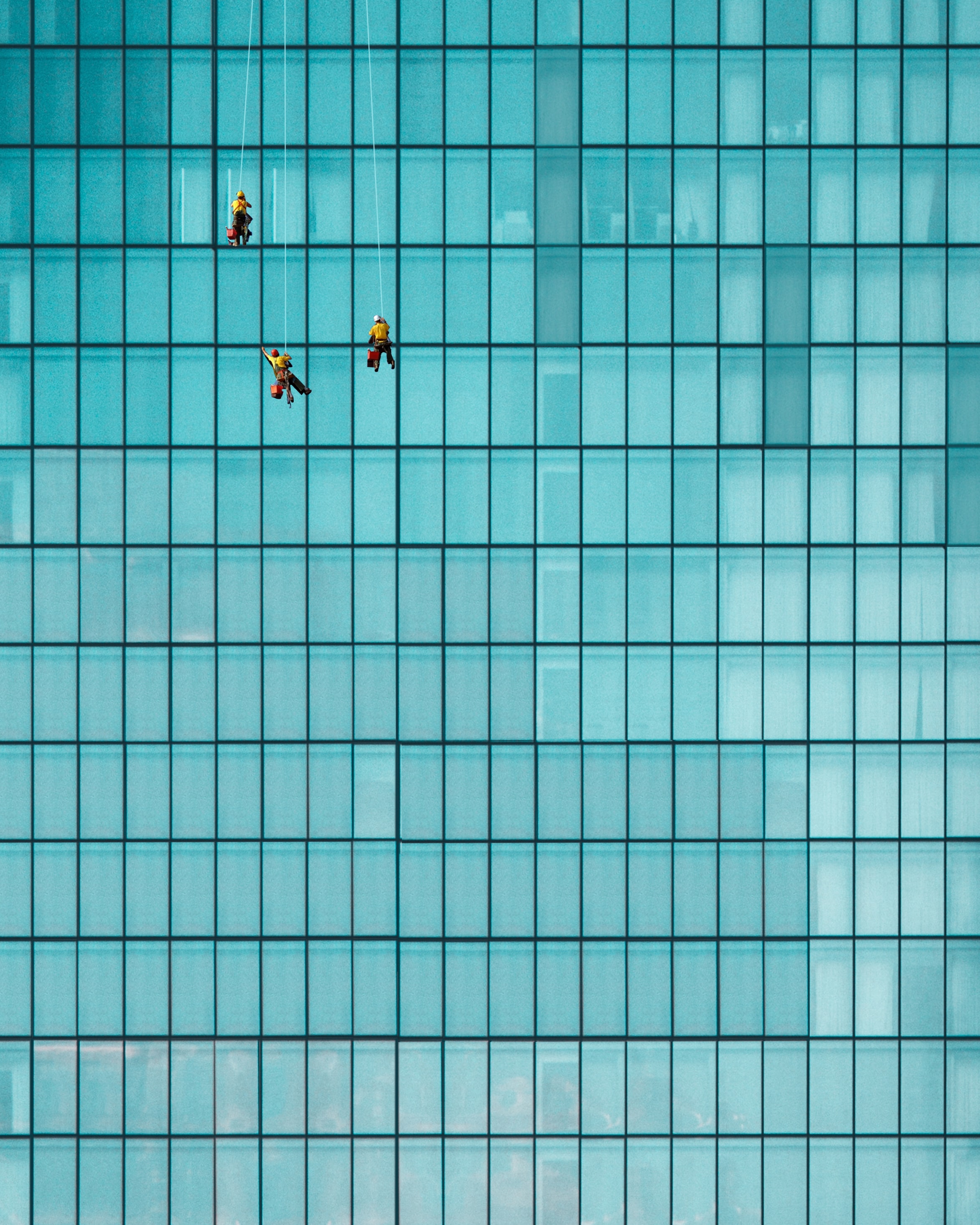 Glass fronted building view of window cleaners on a high rise glass fronted building