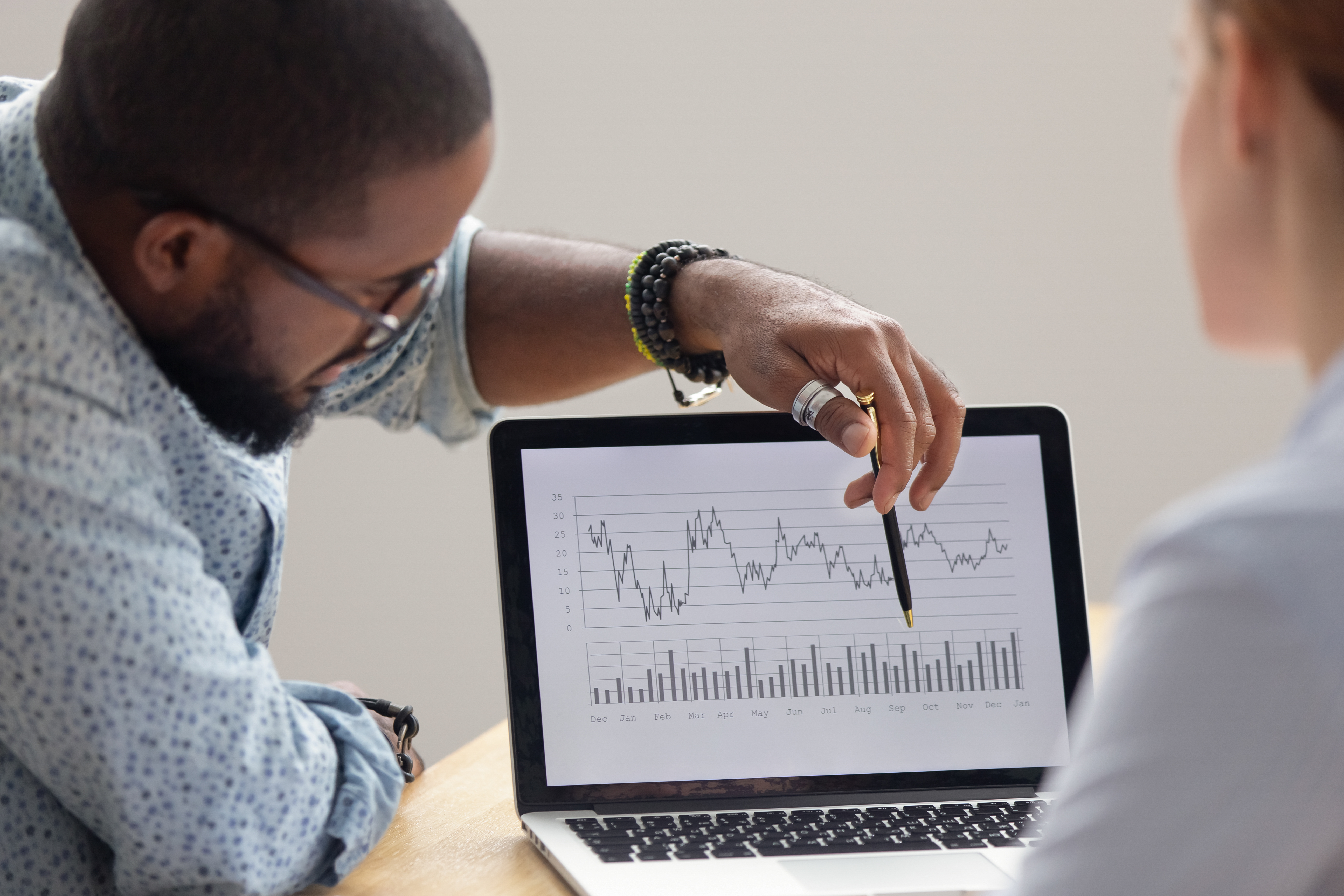 Focused african analyst showing client or colleague annual financial report analyzing business data on laptop screen using software for digital graphic statistic analysis, economic market graphs ; Shutterstock ID 1368244205; Purchase Order: N/A