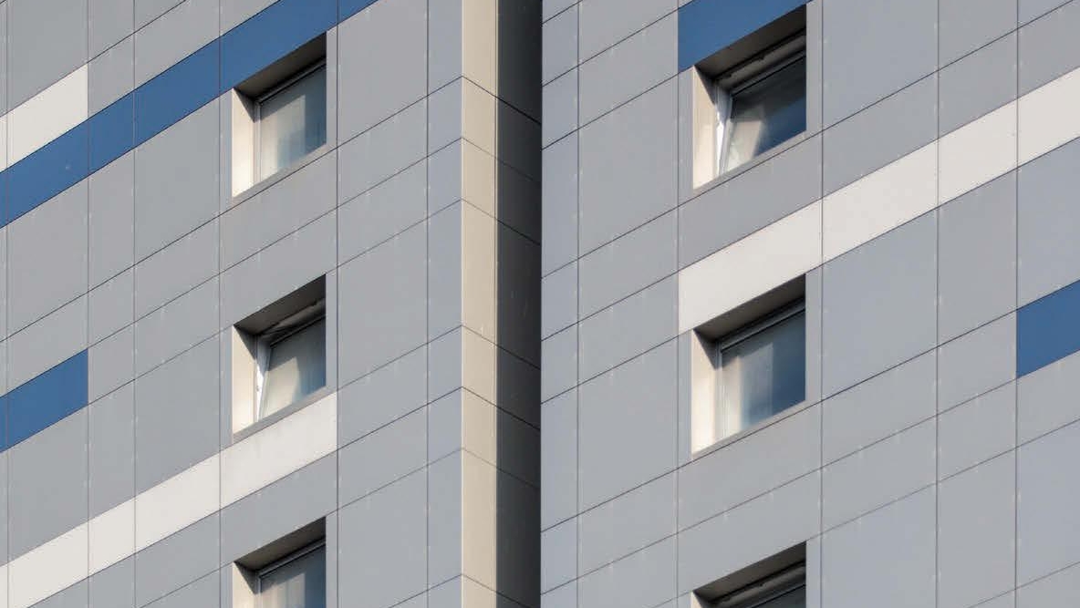 A photo of grey, blue and white cladding on the side of a building