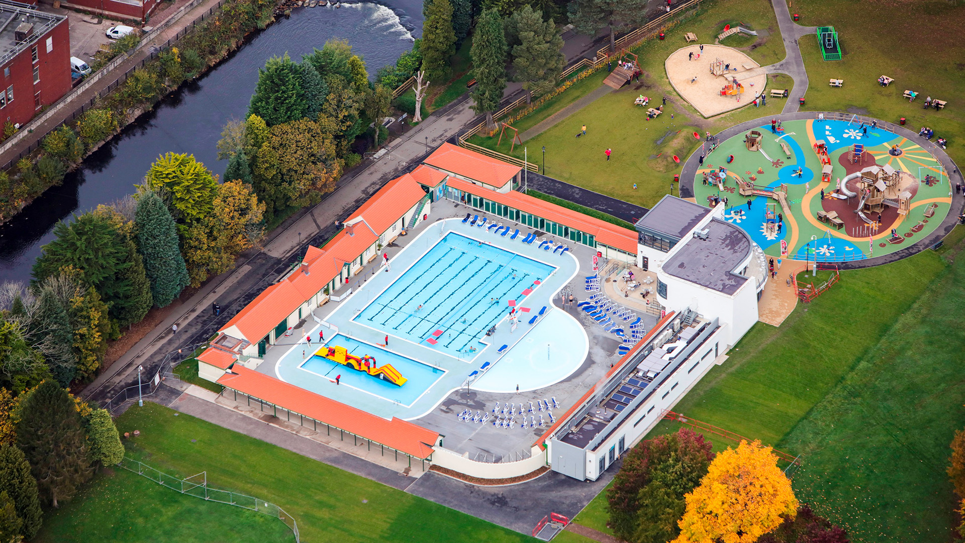 Lido Ponty Aerial view of outdoor pool surrounded by sun loungers, and a playground