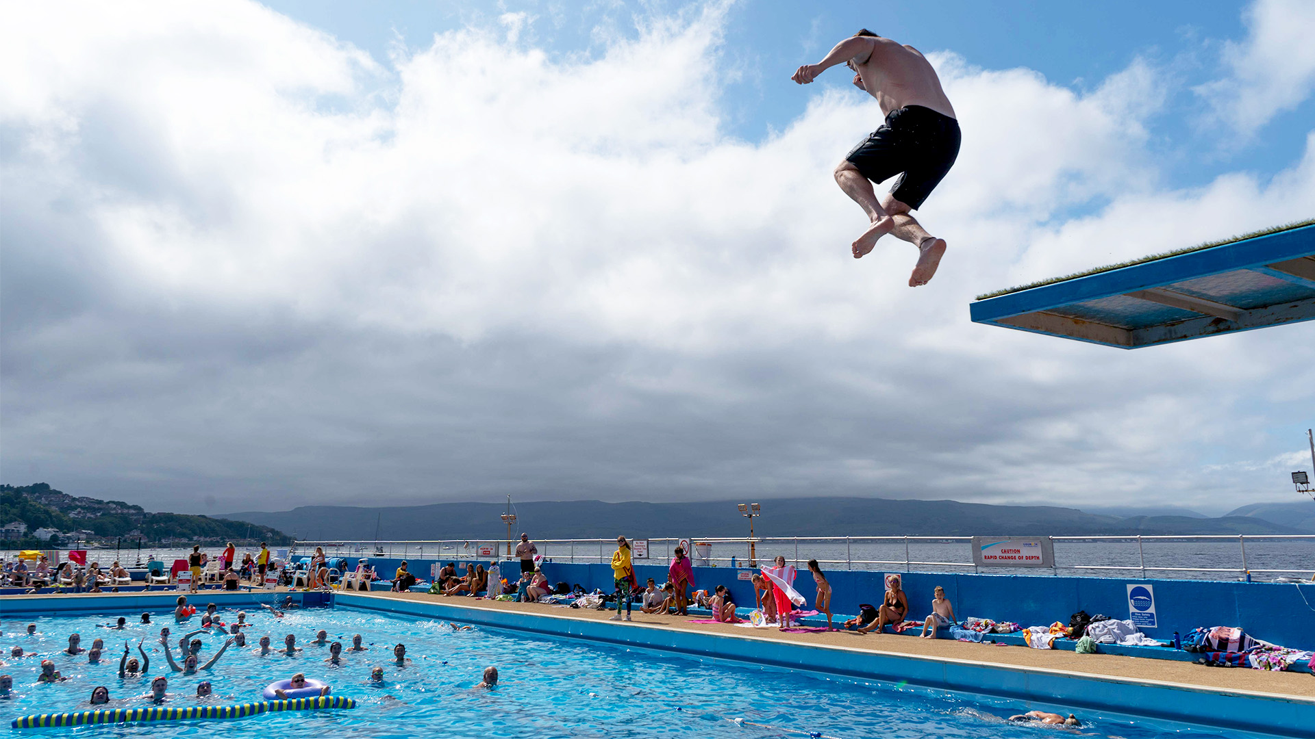 Gourock Outdoor Pool Man diving off board into outdoor pool