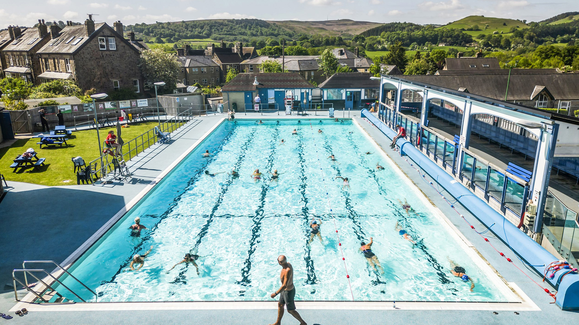 Hathersage outdoor pool People swimming in outdoor pool surrounded by green hills and old houses
