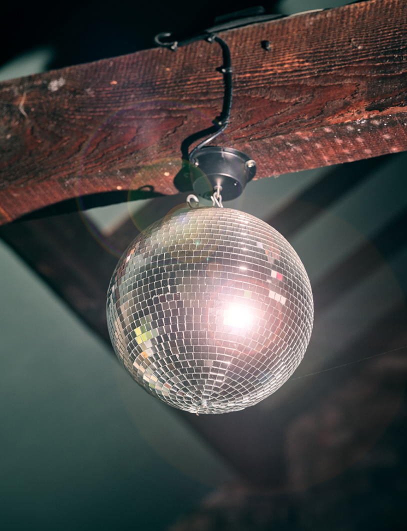 Disco ball hanging from a wooden beam