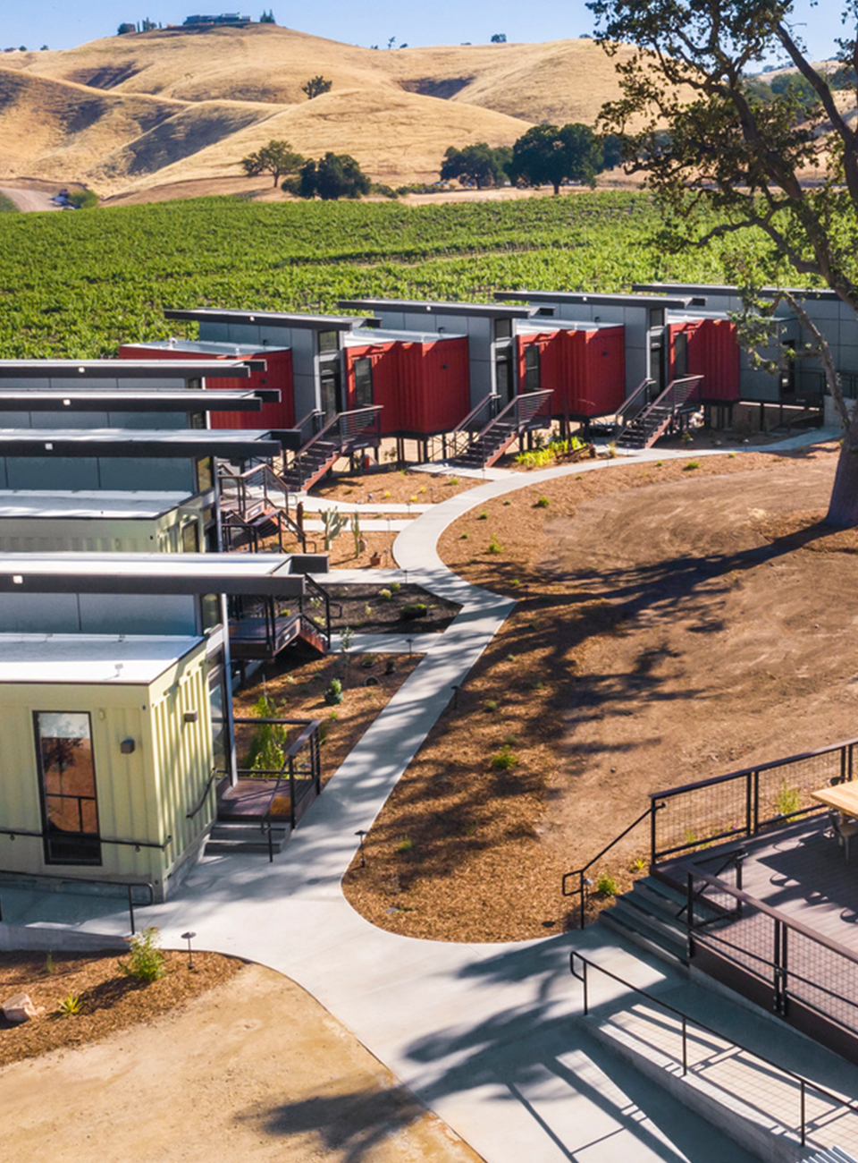 Shipping container hotel rooms with a vineyard and hills in the background