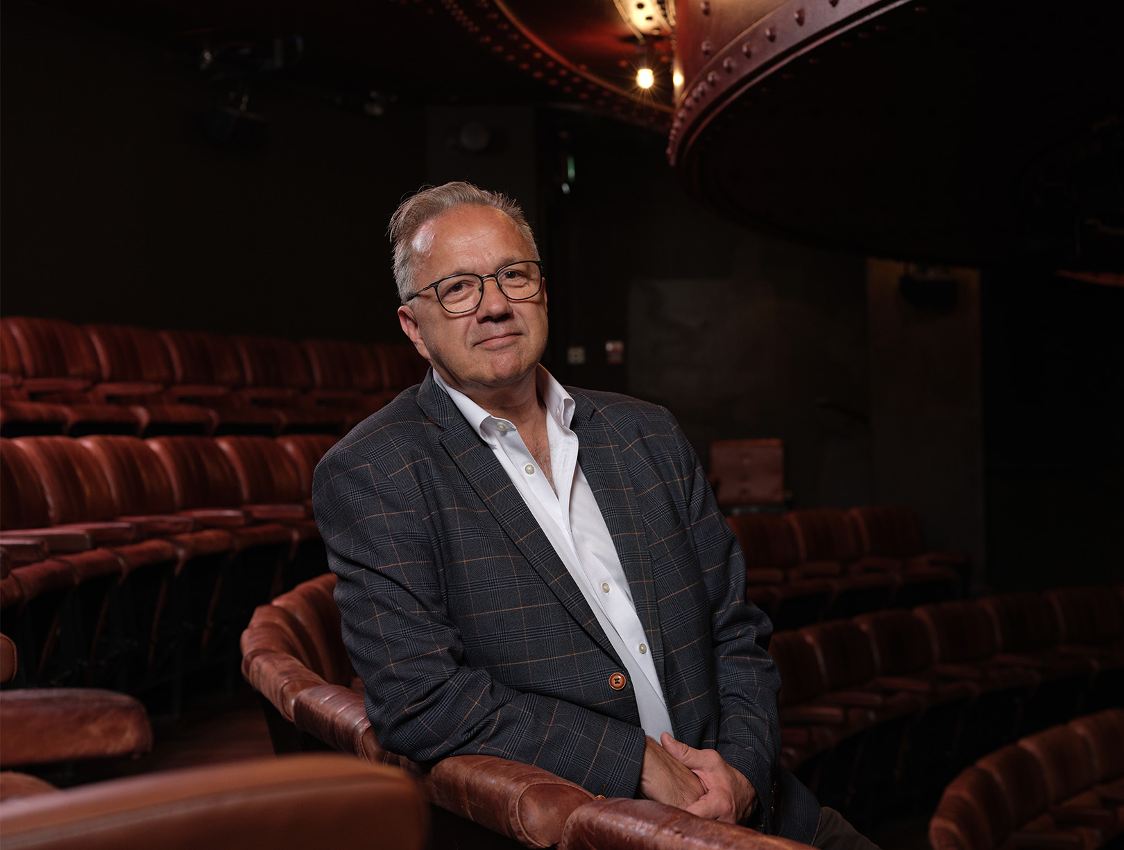 Photo of Guy Middleton MRICS sat on a seat at the Royal Court Theatre