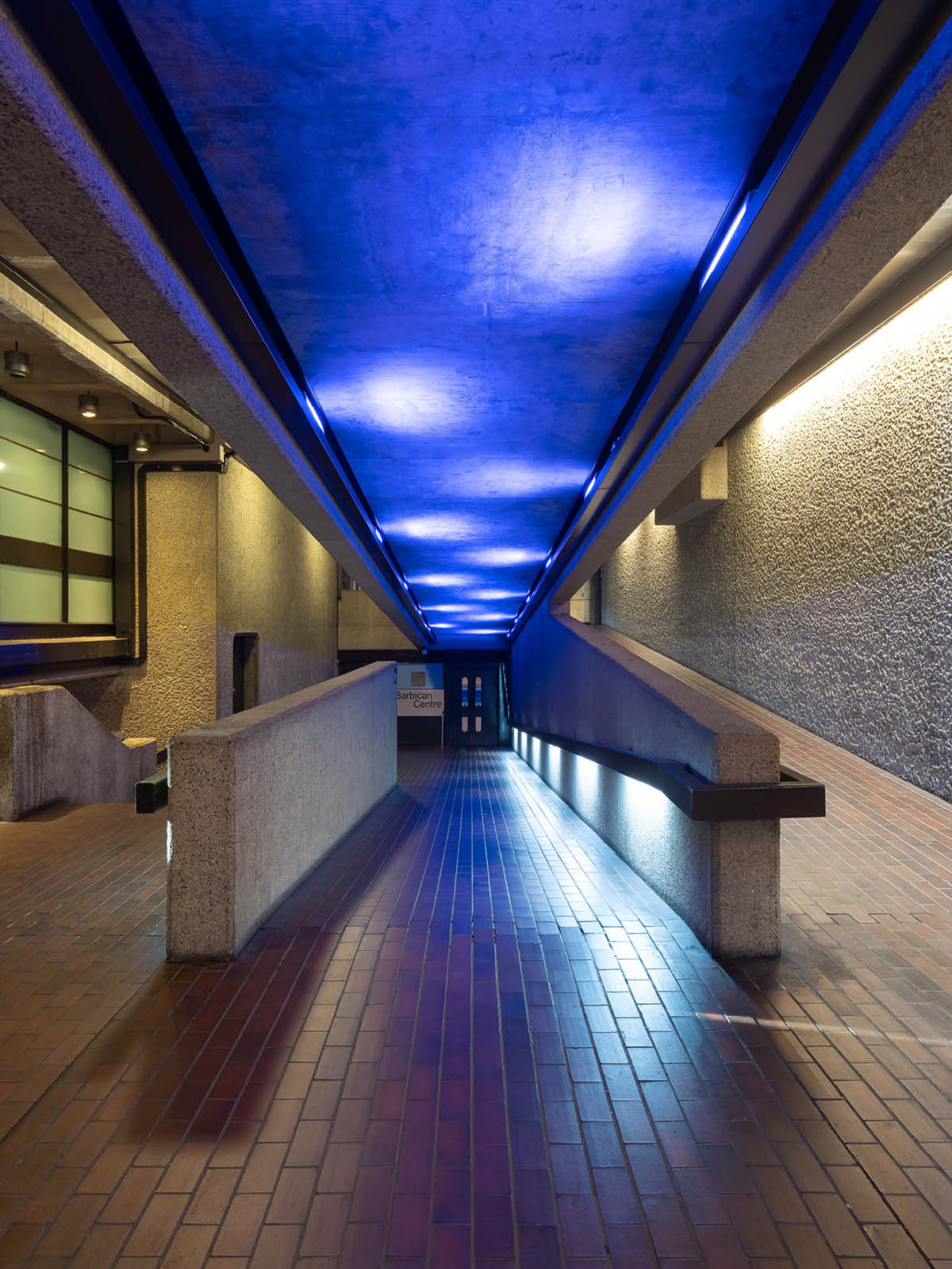 Blue lit corridor of Barbican walkway