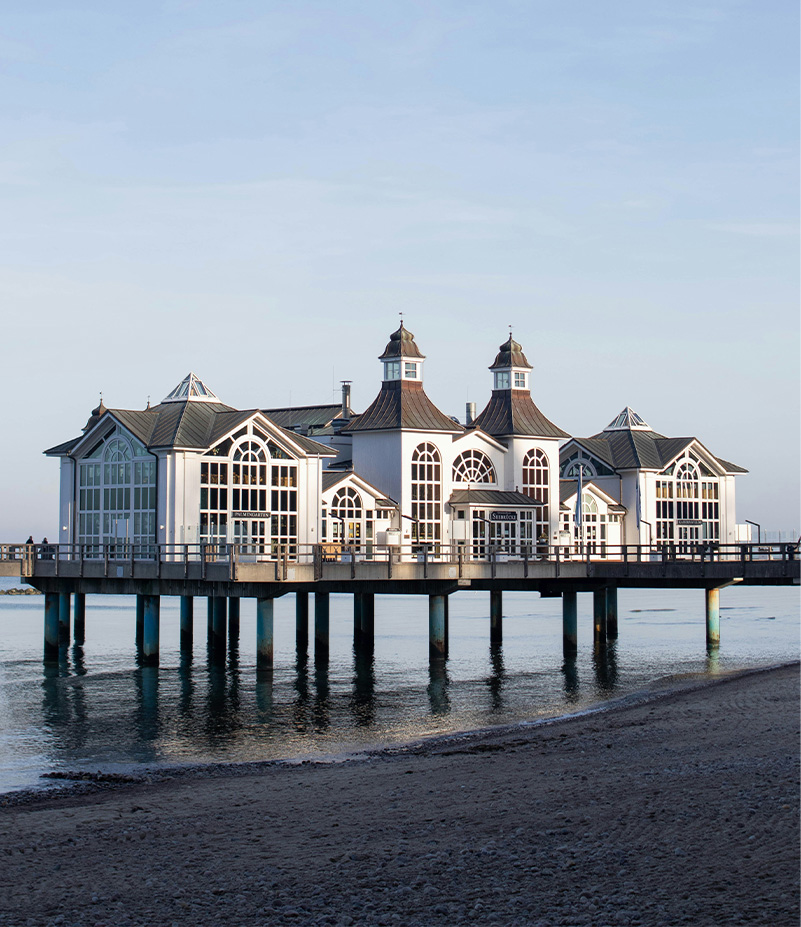 Restaurant building with big glass windows built on pier over the sea