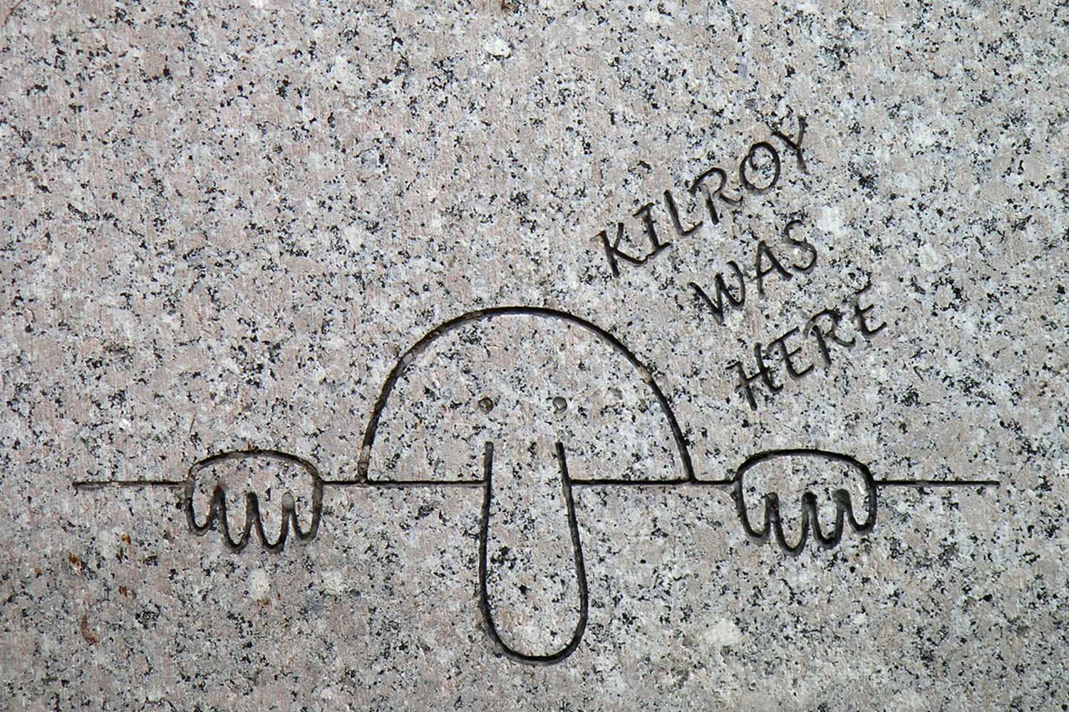 Cartoon character with long nose peering over wall with text saying 'kilroy was here'