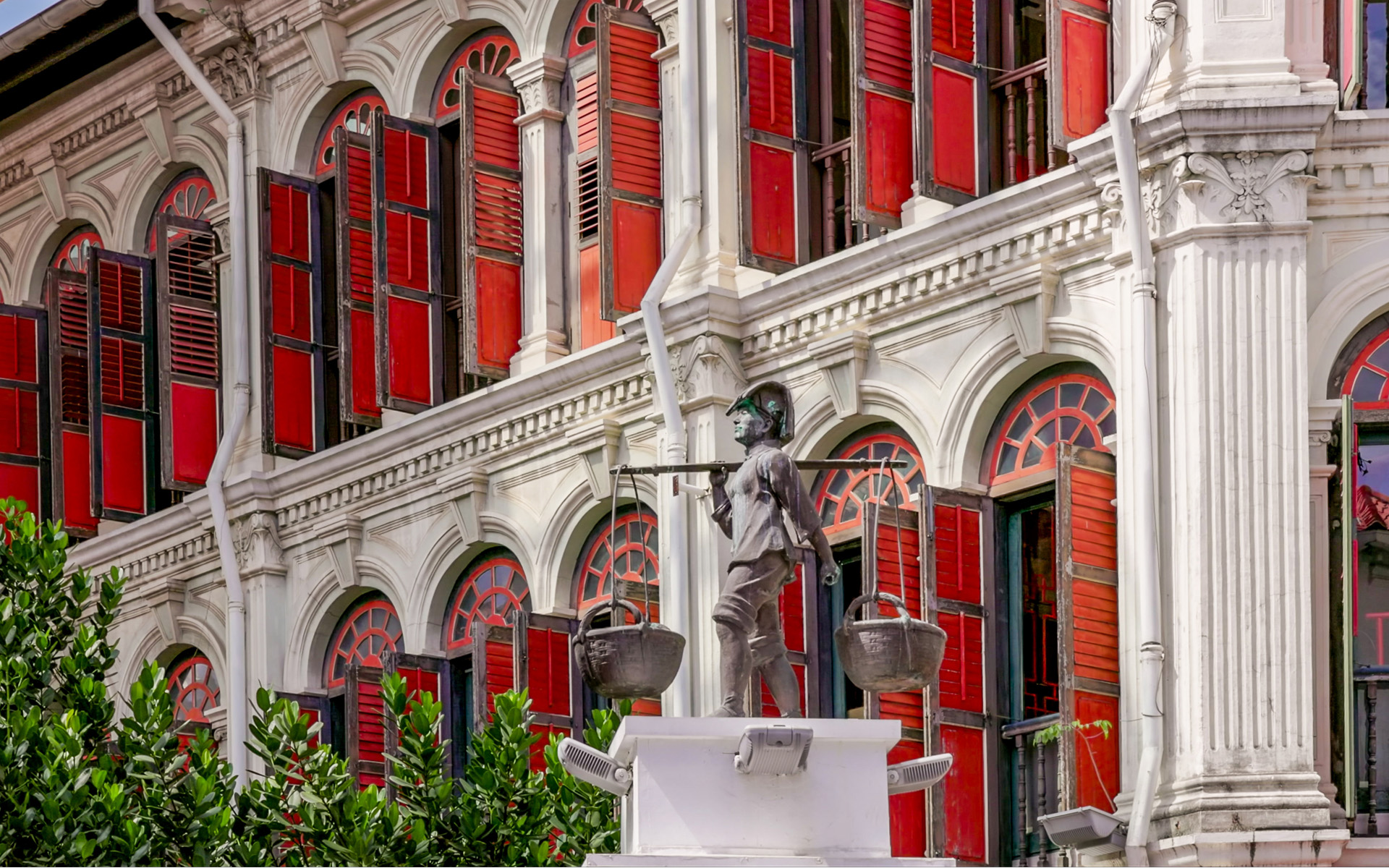A sculpture of a Chinese worker carrying baskets on a pole at Smith Street in Chinatown Photo of a sculpture of a Chinese worker carrying baskets on a pole at Smith Street in Chinatown