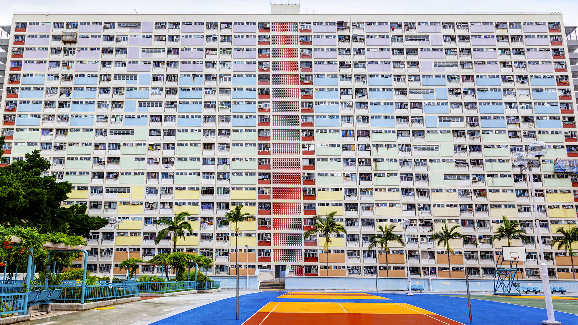 Basketball court in front of colourful apartment building