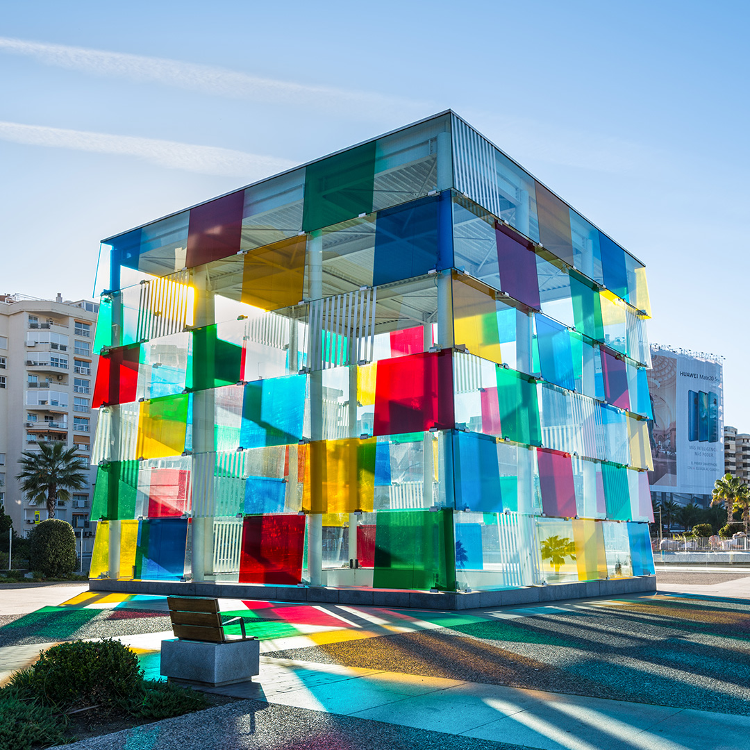 Sun reflecting light through colourful square glass building