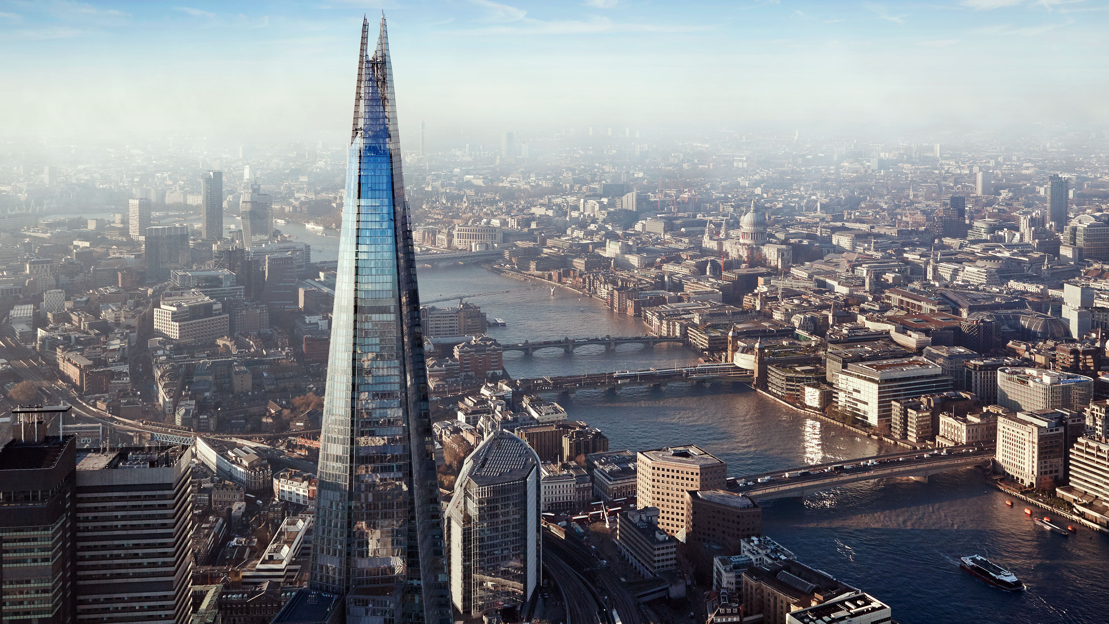 Aerial view of The Shard in the foreground and the Thames and London skyline