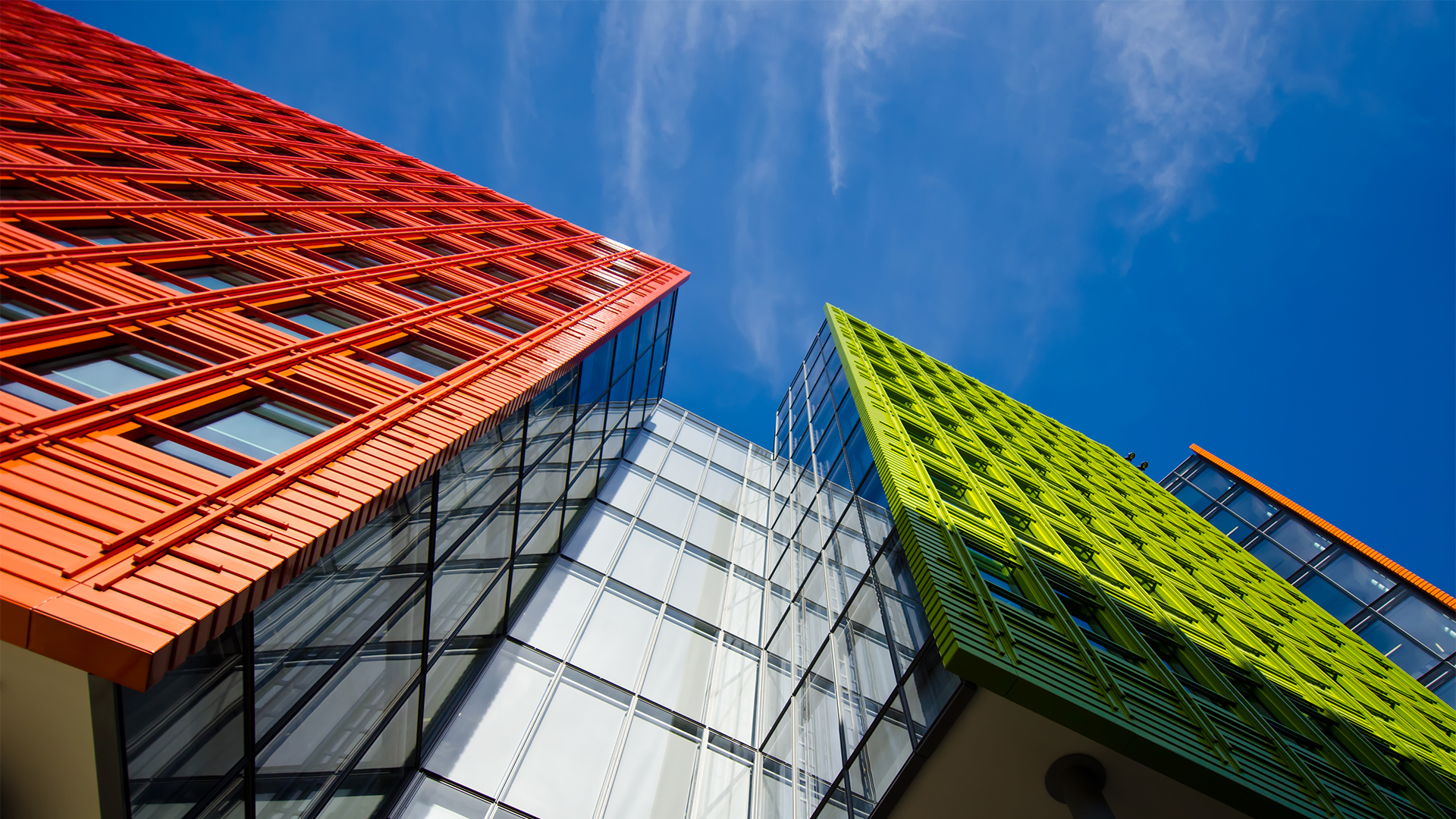 Photo of a red and green commercial building with a blue sky