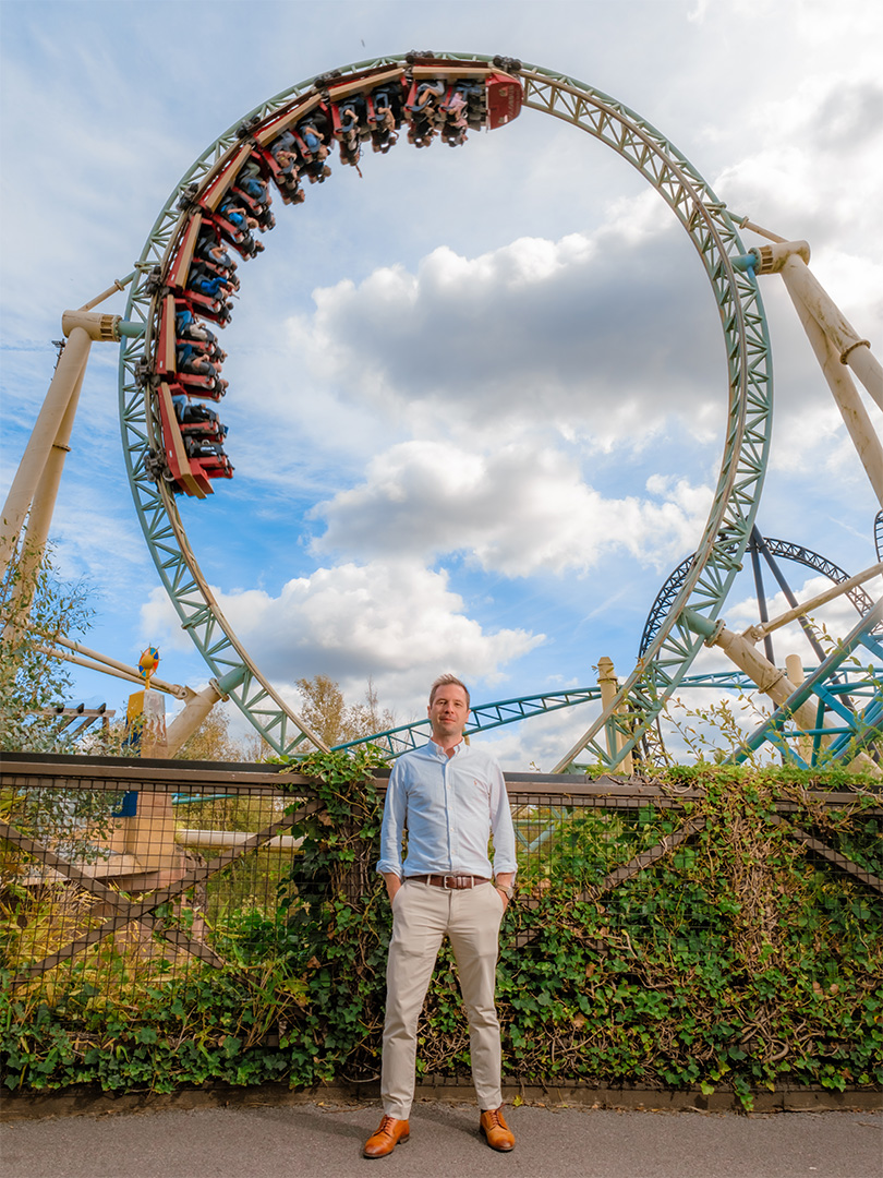 Christopher Bird MRICS in front of an upside down rollercoaster