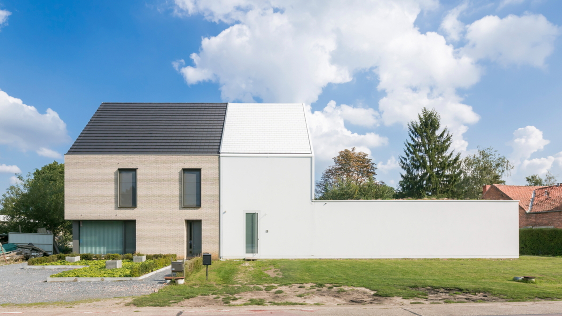 House split in two sections. Left hand side beige with windows and the right side white plain plasterboard