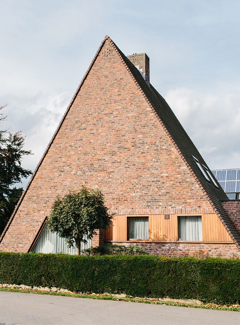 A photo of a Belgium house in the shape of a triangle.