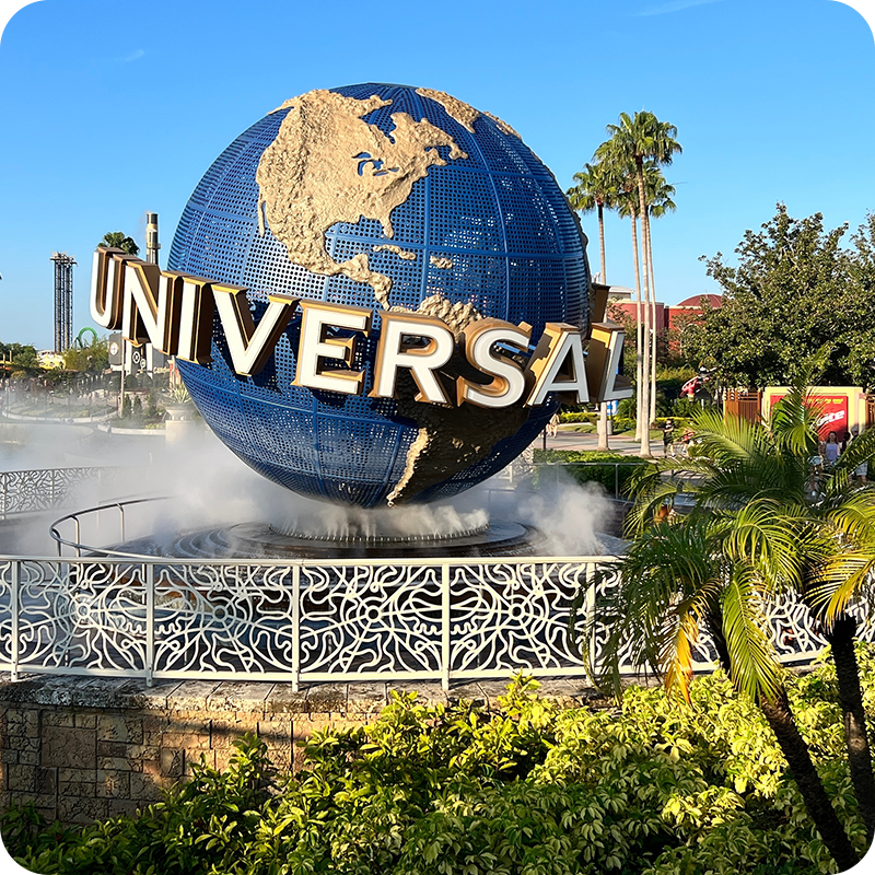 Globe with universal logo amongst palm trees