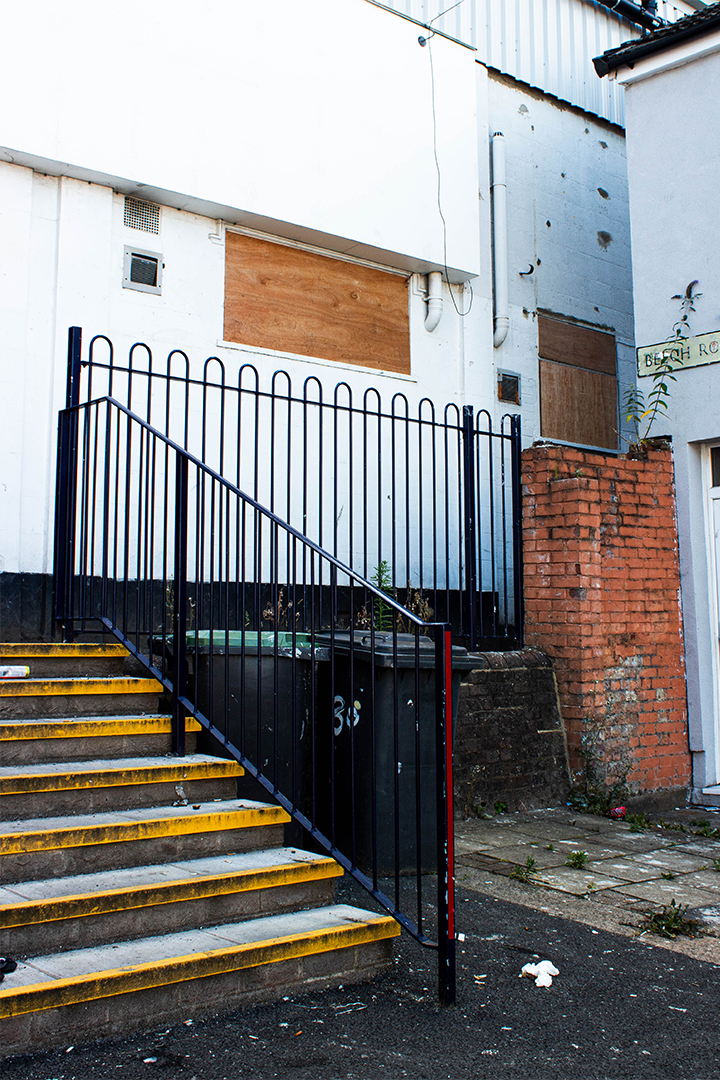 Wheelie bins next to stairs leading up to the entrance of the stadium