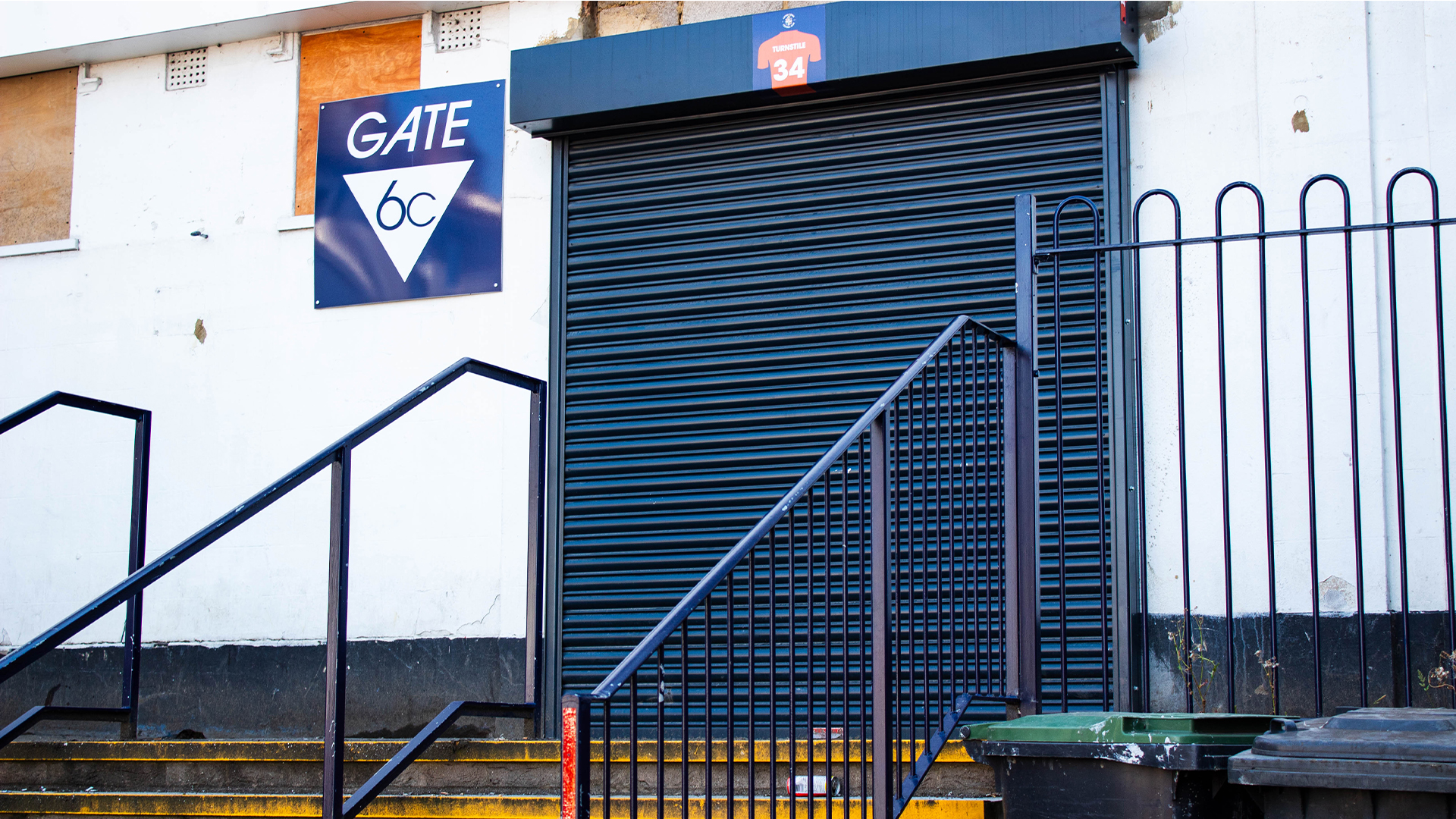 Steps leading up to blue shuttered gate