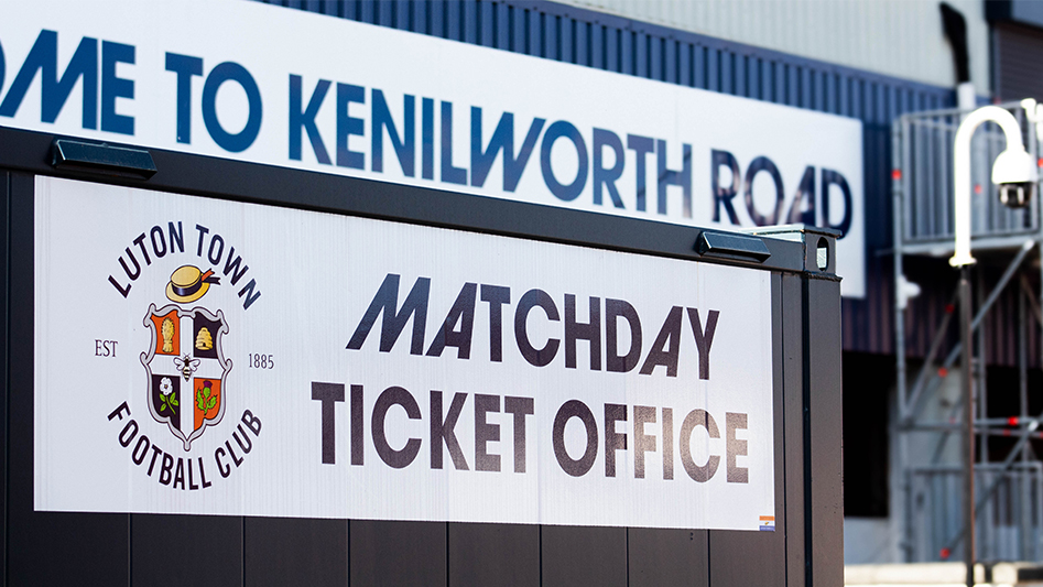 Matchday ticket office box in the foreground with kenilworth road in the background