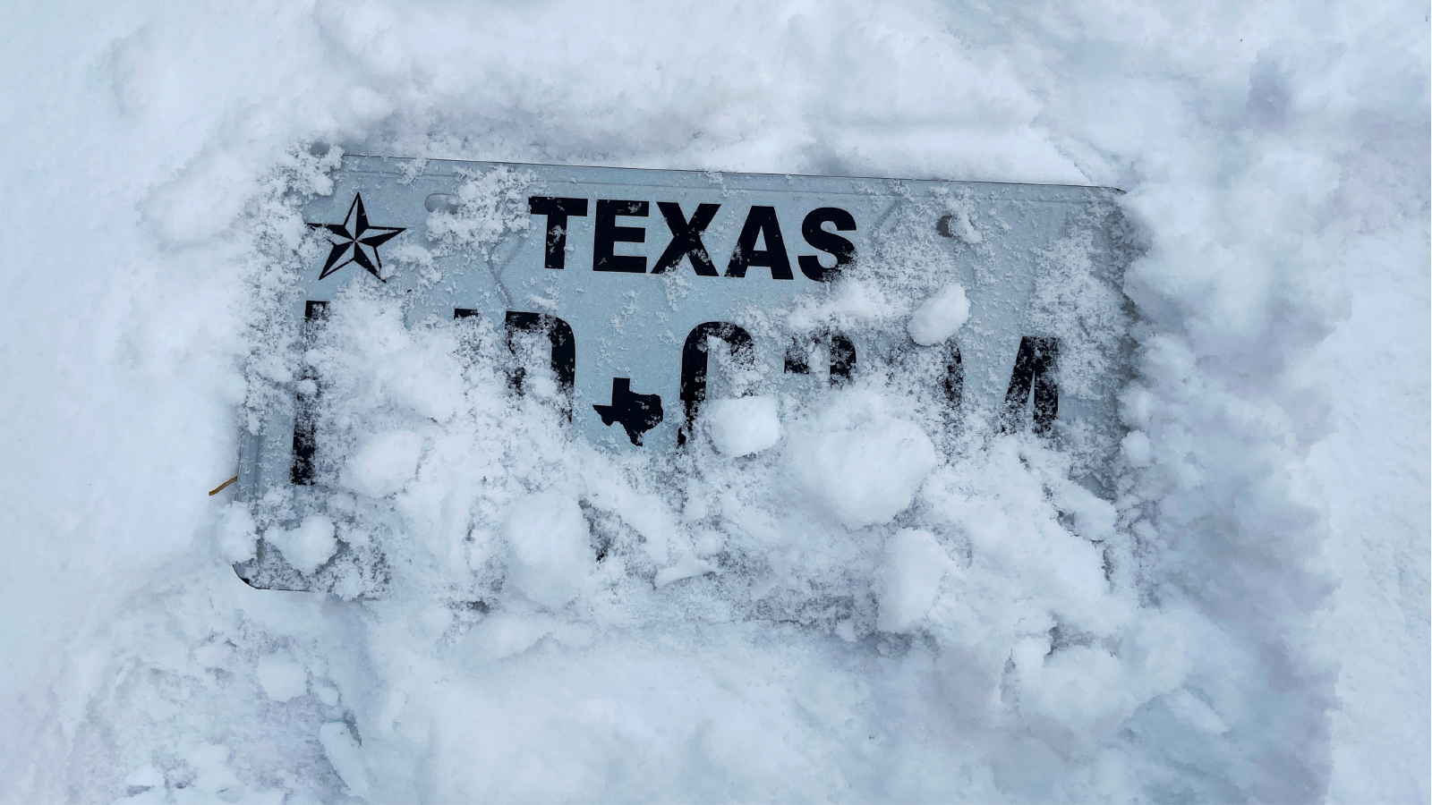 Texas number plate covered in snow
