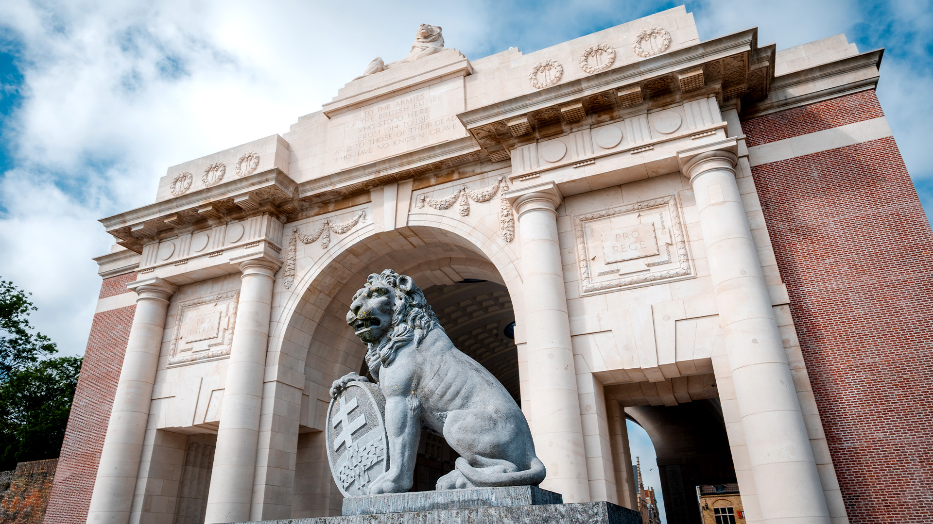 A photo of the lion statue in front of a refurbished Menin Gate