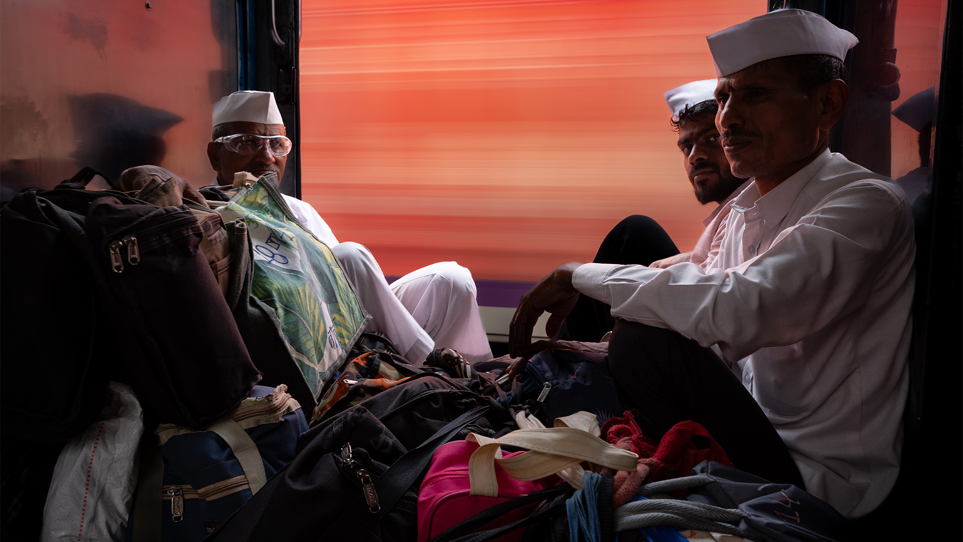 Photo of Dabbawalas sat on a train as another passes