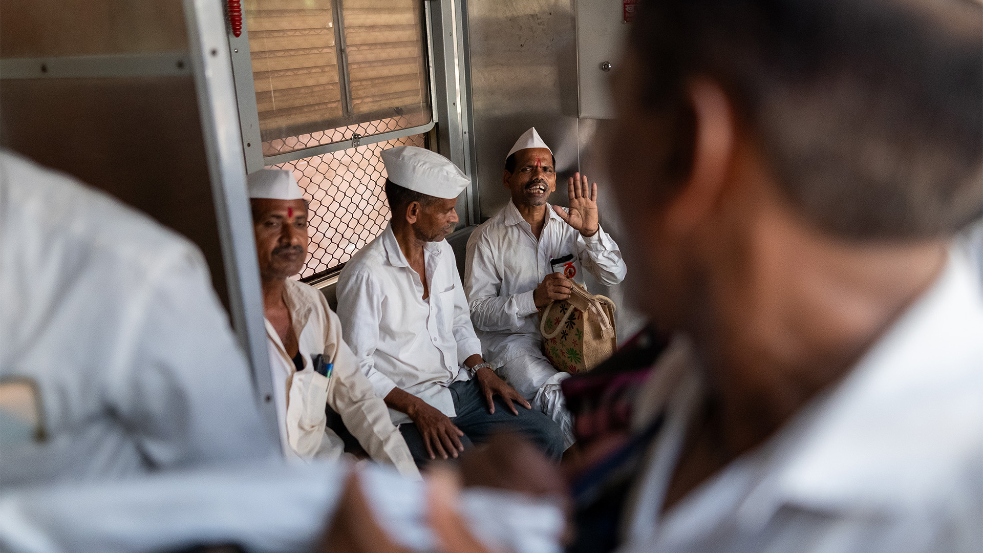 Photo of Dabbawalas sat on a train