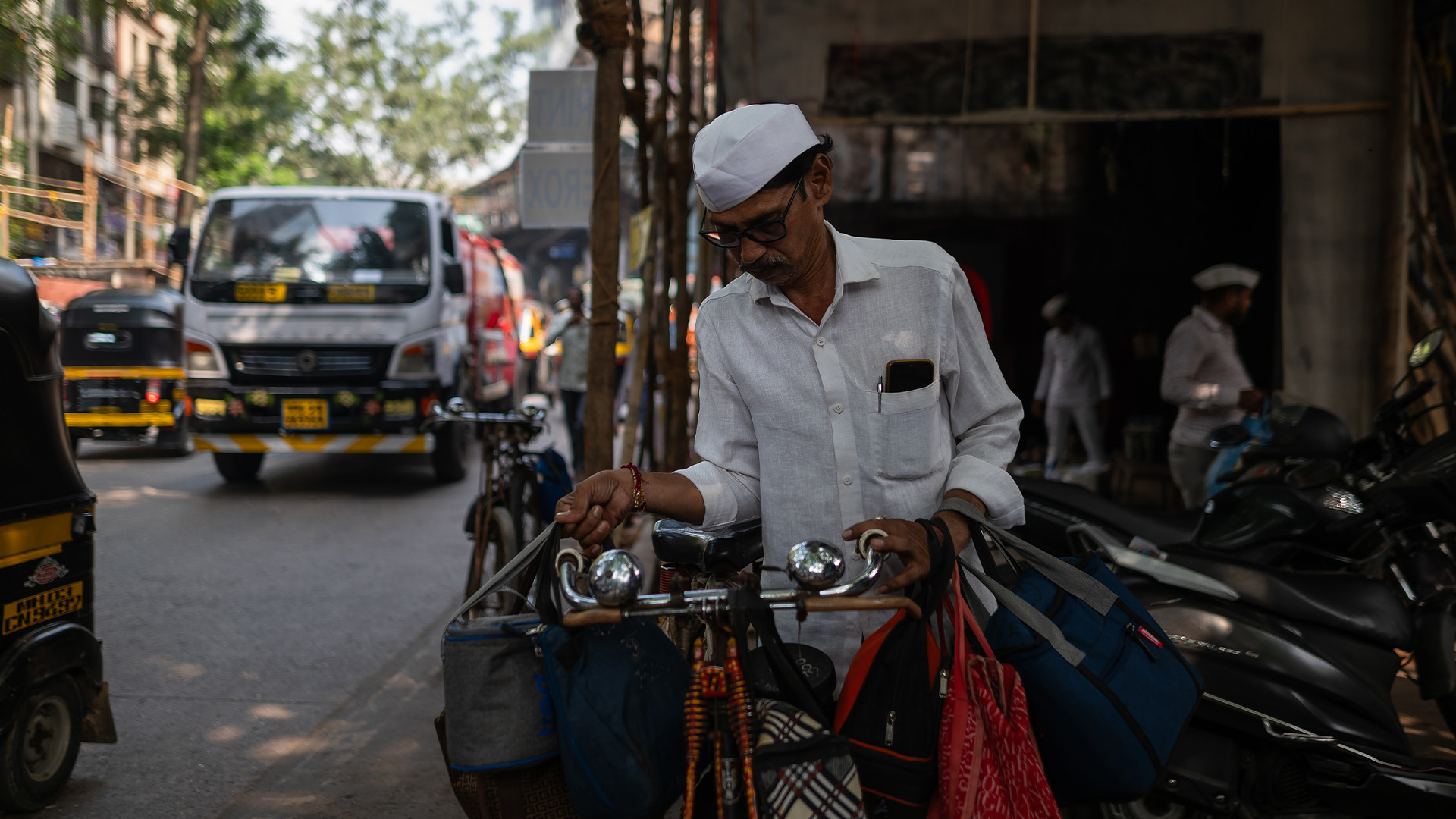 Dabbawala puts lunch bags on his bike