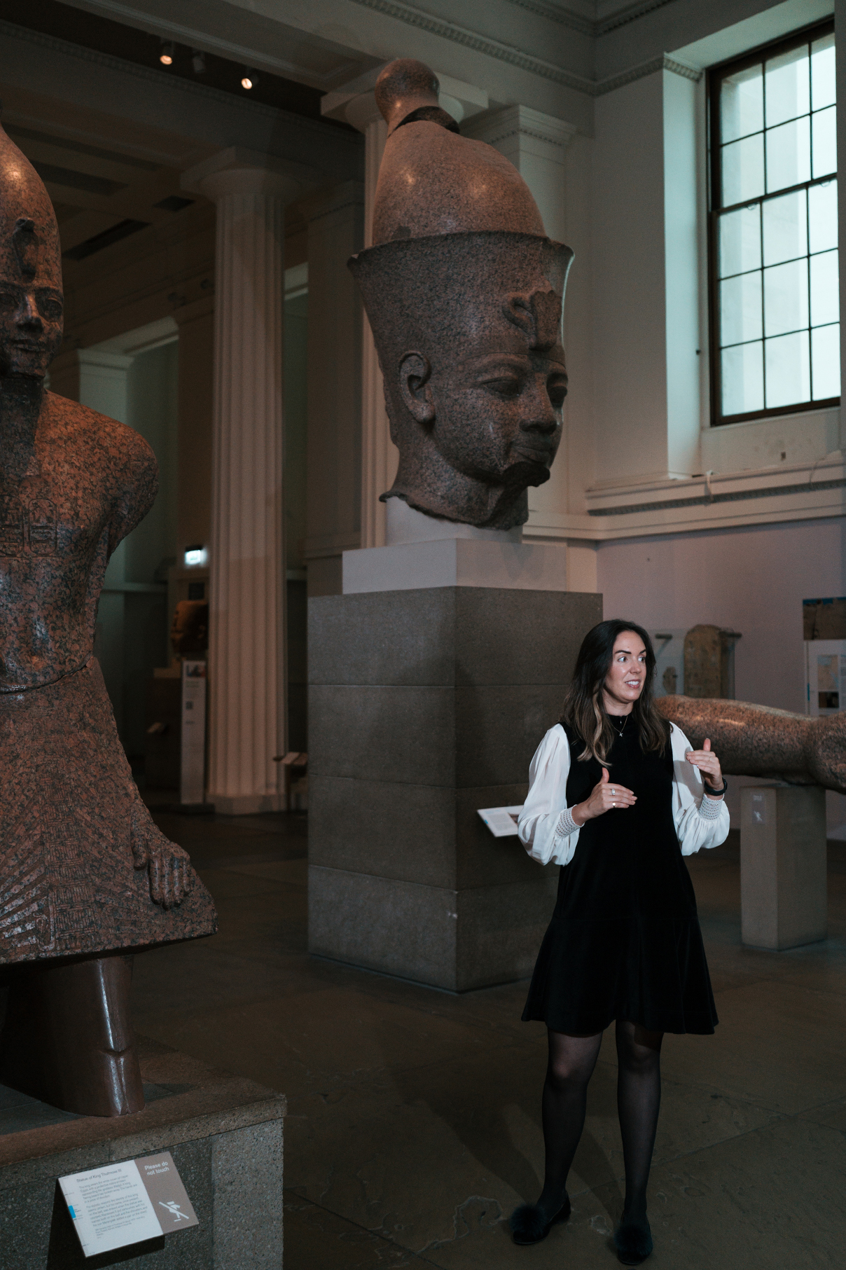 Katharine stands between two giant Egyptian sculptures