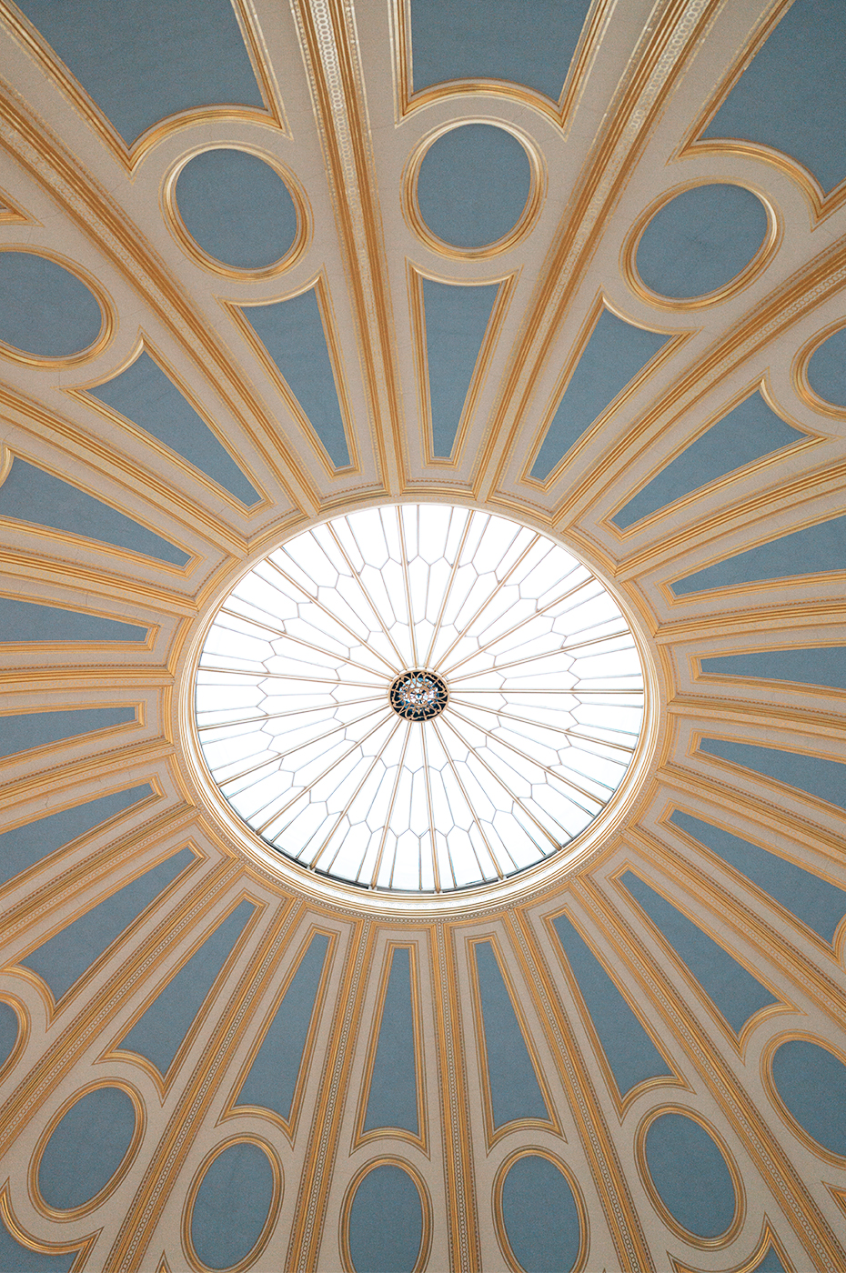 Close up of a domed ceiling painted in blue with gold detailing