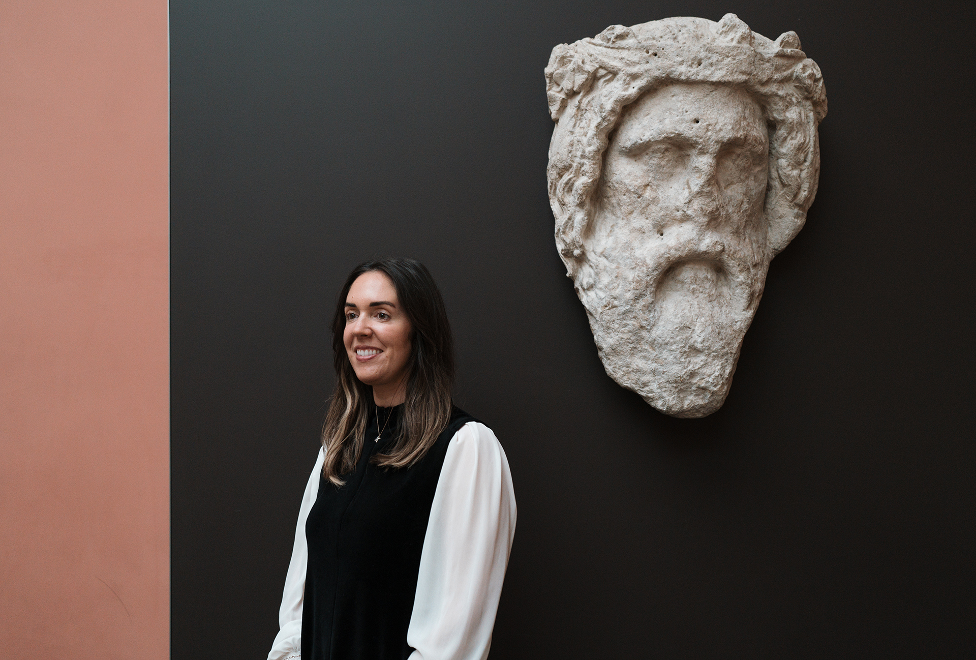 Katharine stands next to a marble head