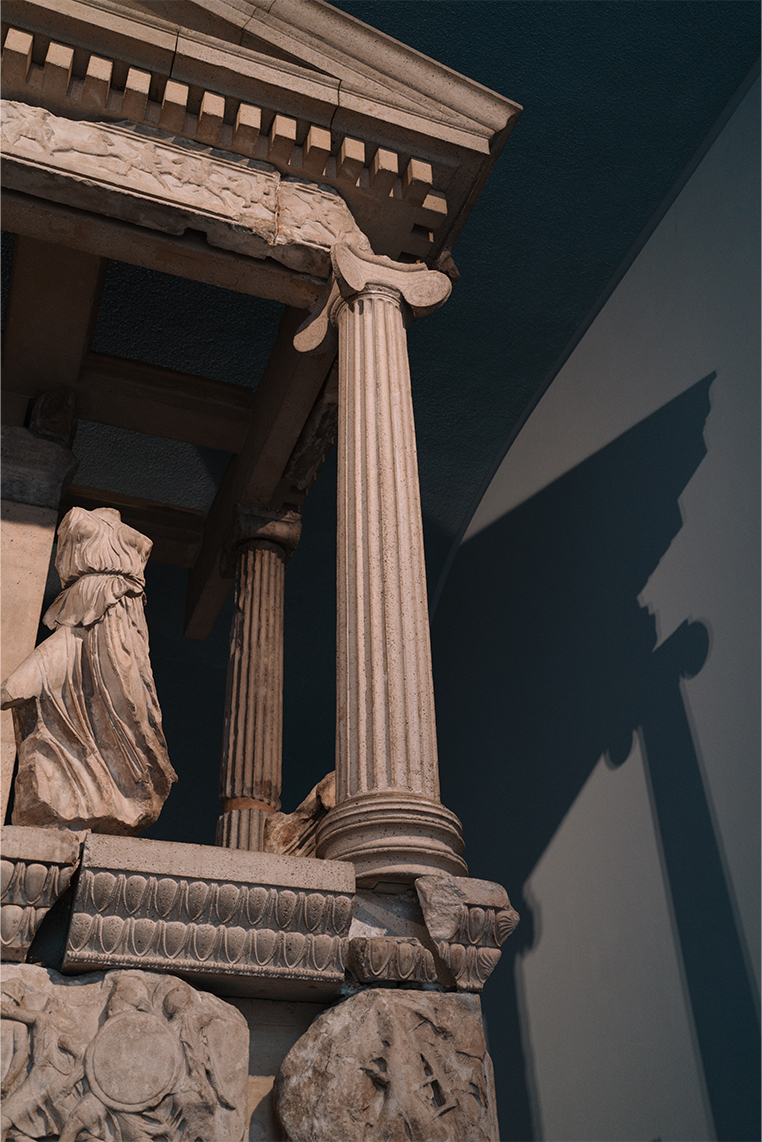 Ancient Greek temple sculpture casting strong shadow on wall