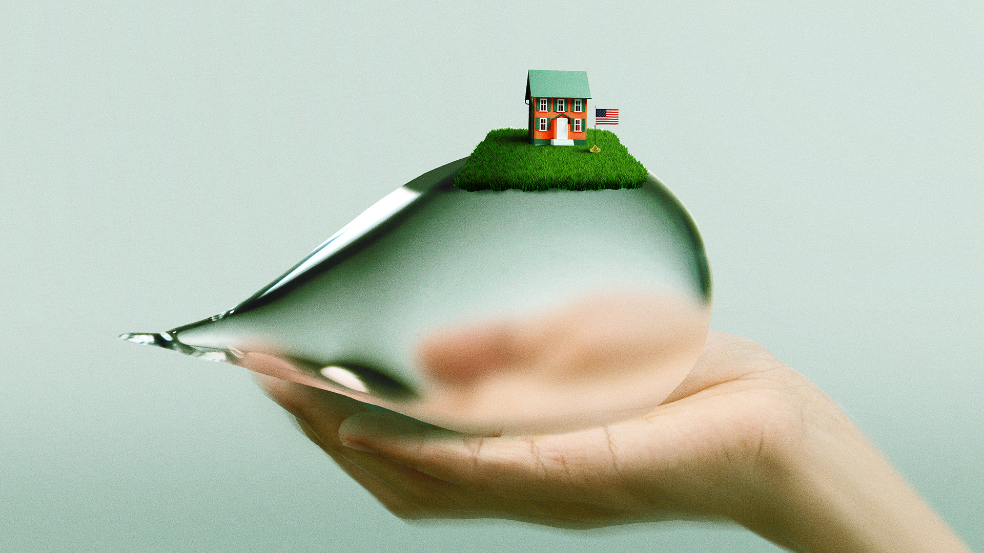 Hand holds a giant water droplet with a typical American house on top