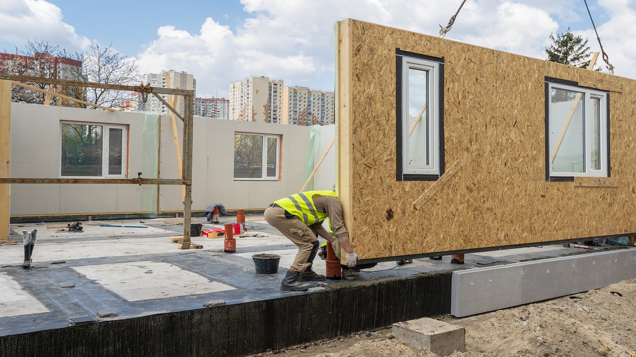 Process of construction new and modern modular house from composite sip panels. Worker man in special protective uniform wear working on building development industry of energy efficient property; Shutterstock ID 1479257123; Purchase Order: na