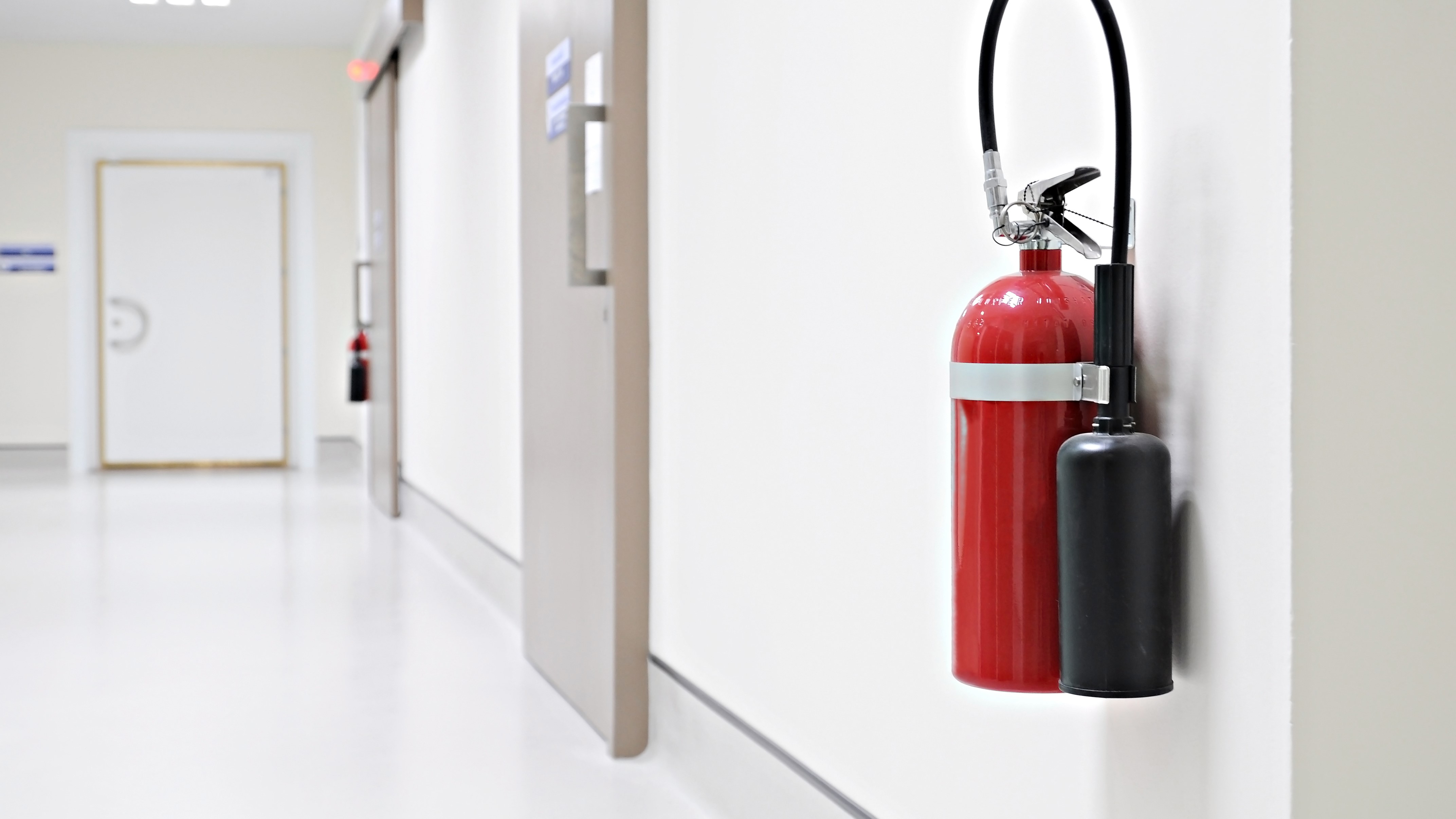 Fire extinguisher on white wall