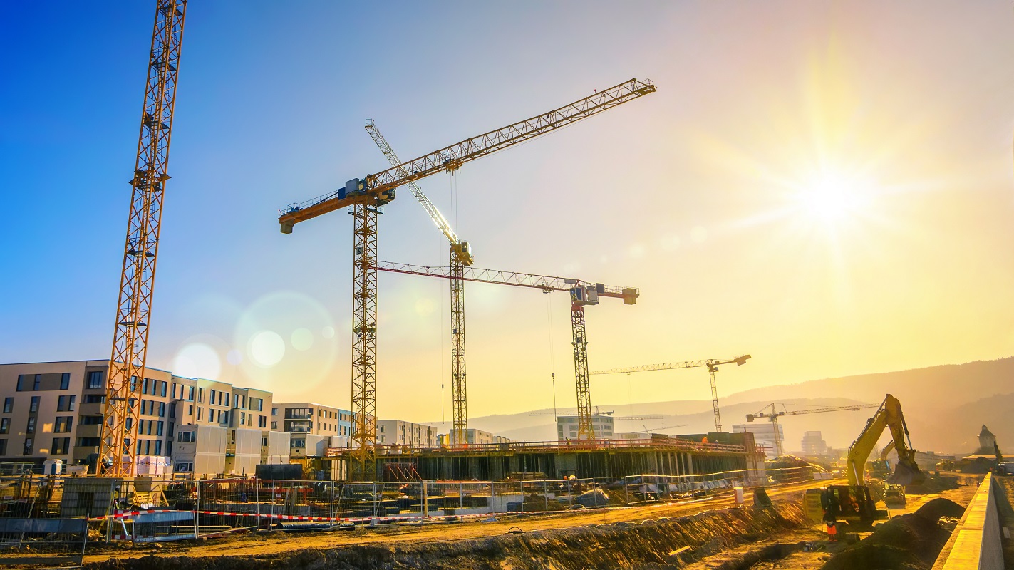 Large construction site including several cranes working on a building complex, with clear blue sky and the sun; Shutterstock ID 559826938; Purchase Order: -