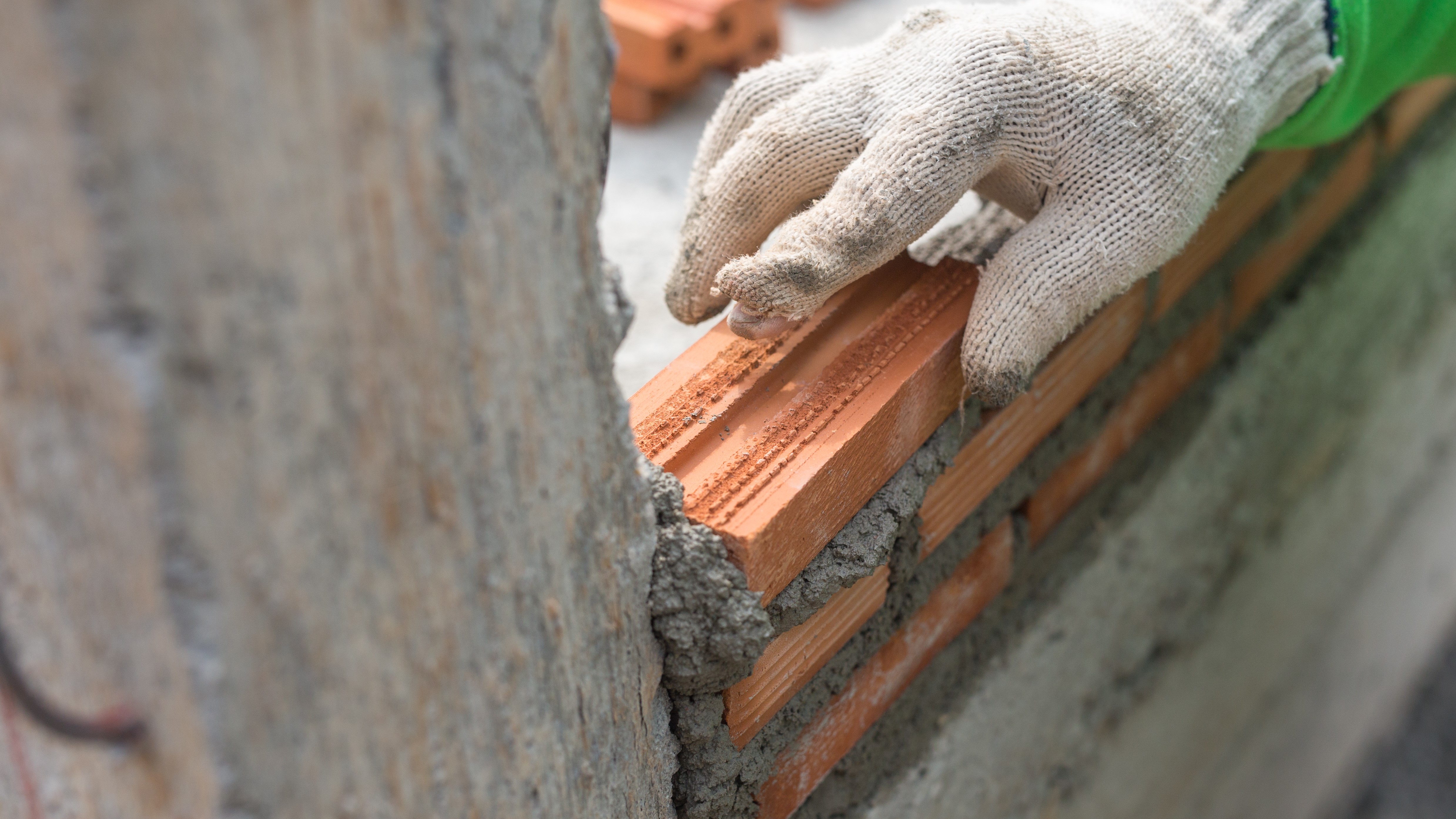 Close up of hand laying bricks