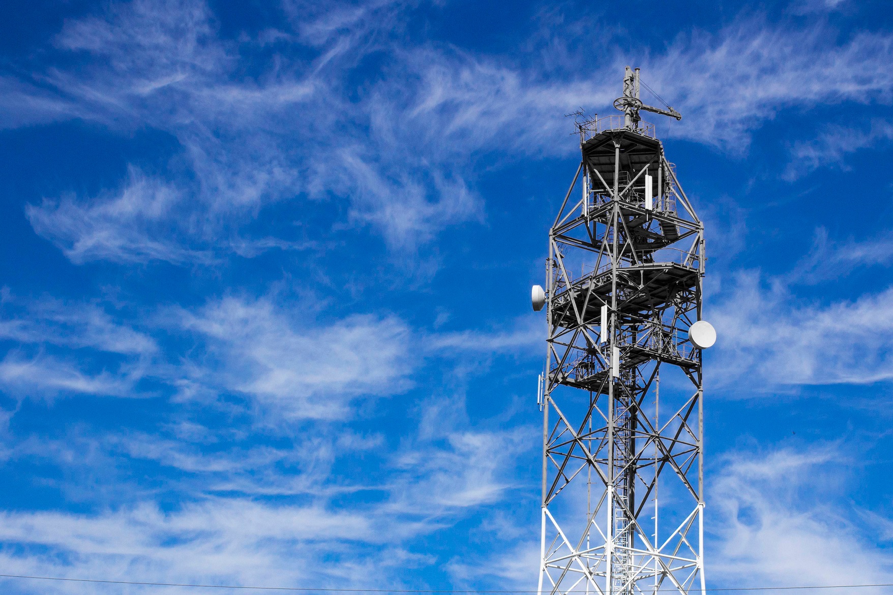 Telecommunication technology, Telecom tower mast or antenna for mobile cellular gsm telephony internet network wifi used to broadcast wireless radio digital signal on blue sky copy space background; Shutterstock ID 1759689614; Purchase Order: -