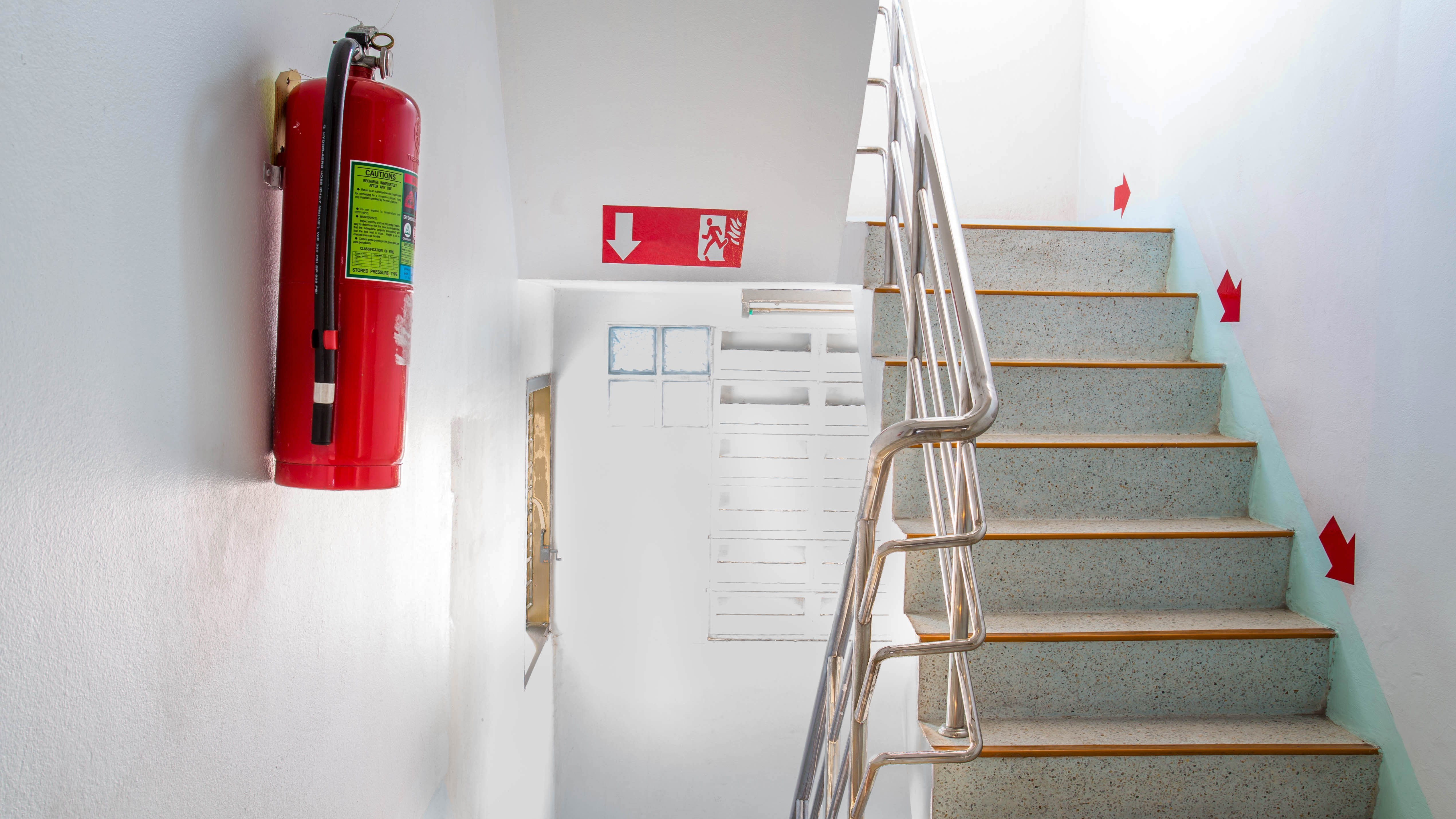 Fire extinguisher on wall next to staircase